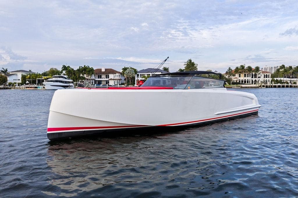2016 Vanquish Yachts VQ48 luxury yacht on calm water, with scenic waterfront backdrop.