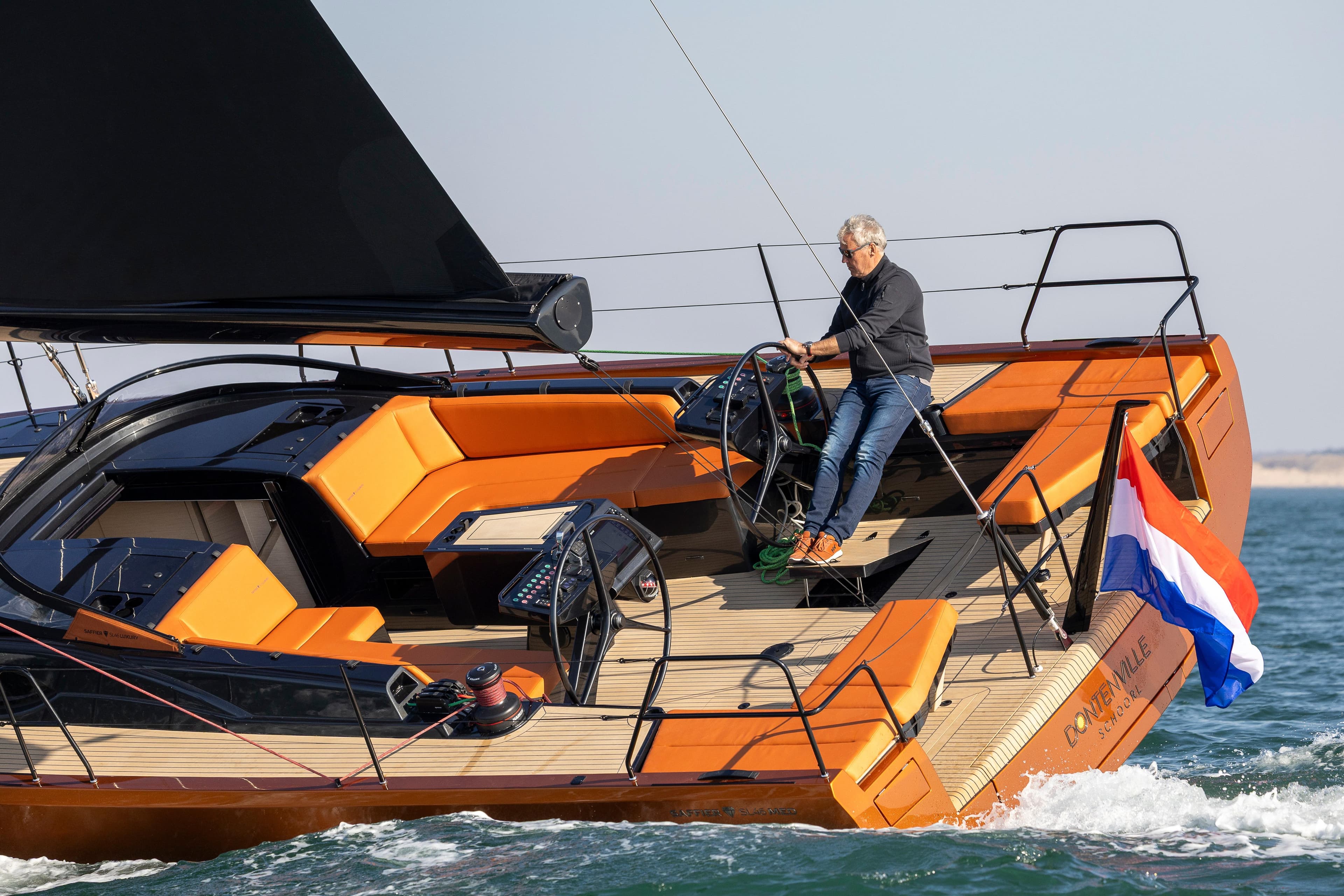Saffier SL 46 MED 2027 yacht sailing with Dutch flag, featuring sleek design and vibrant orange seating.