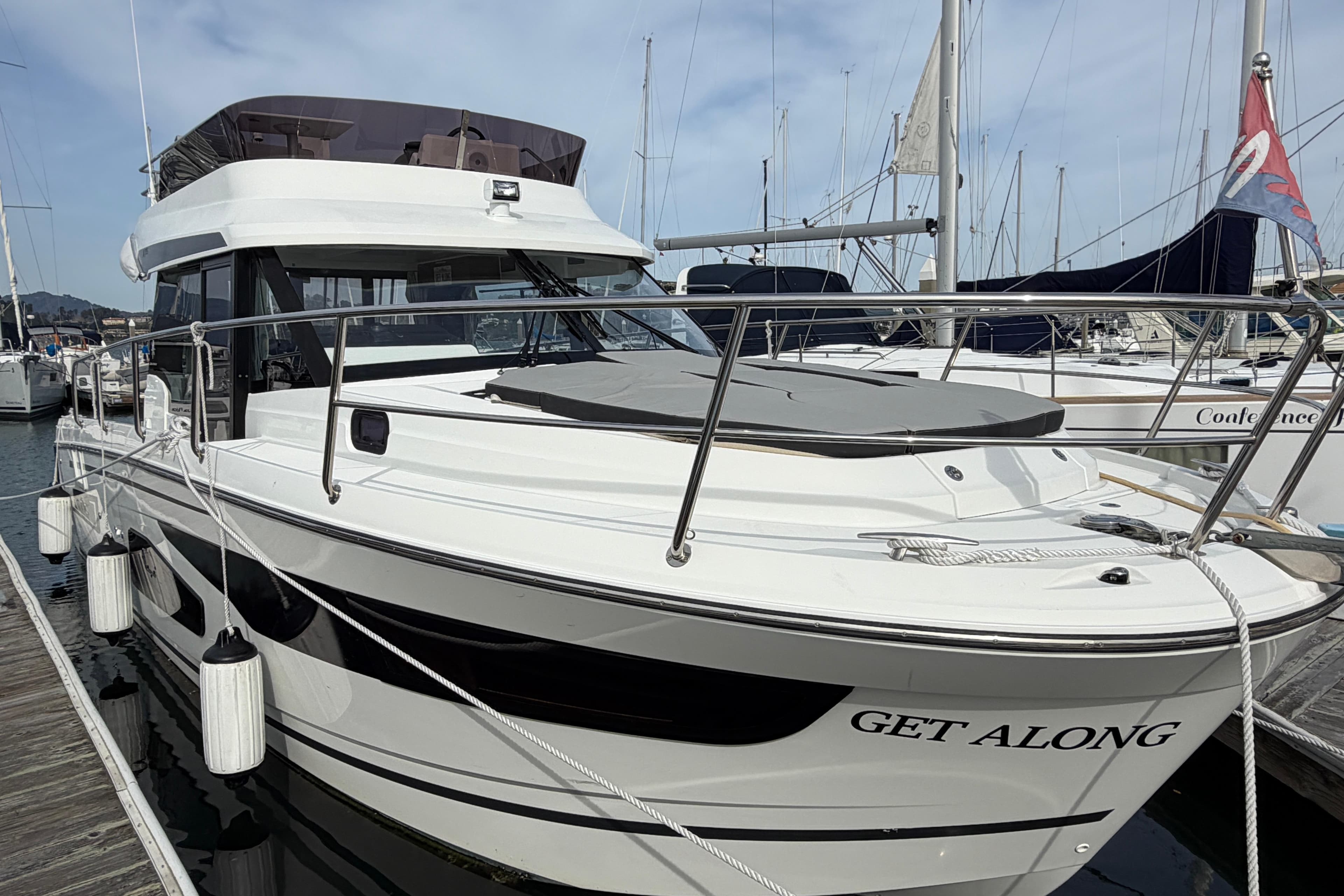 2022 Jeanneau NC Weekender 1095 Fly docked at marina, side view.