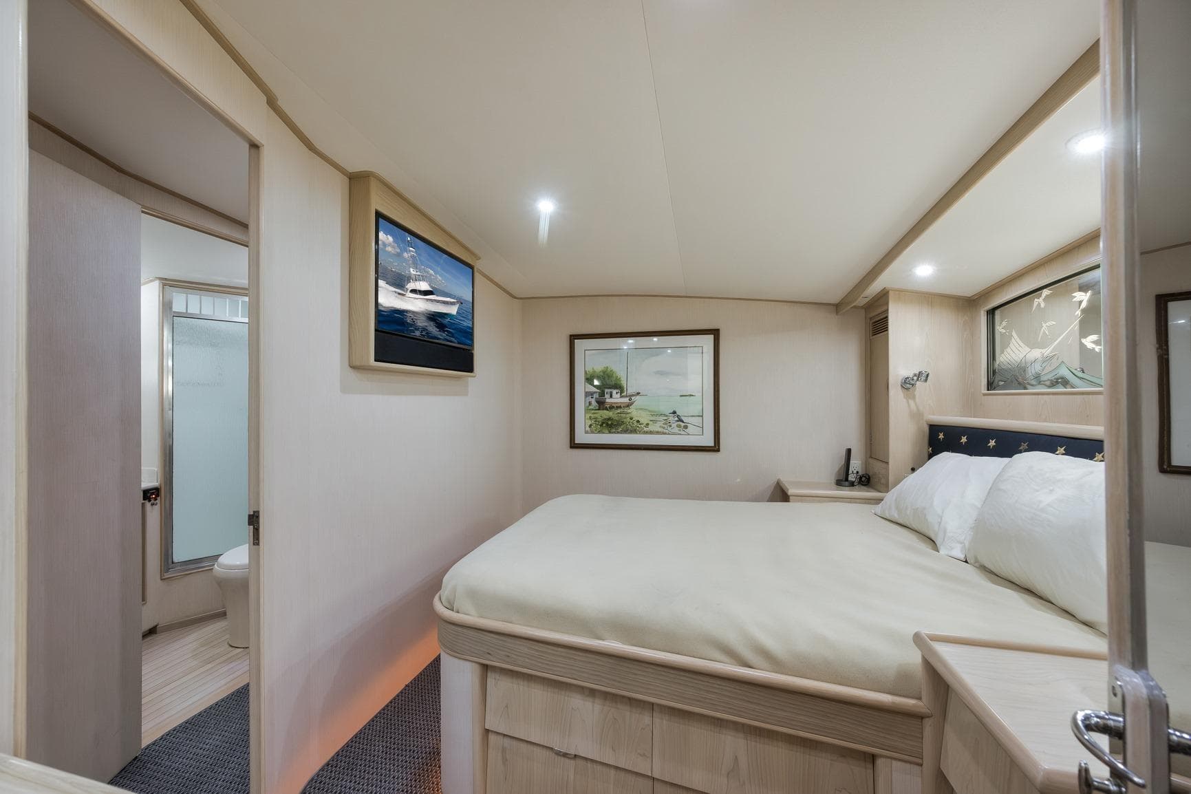 Luxurious 1998 Rybovich Convertible yacht bedroom with elegant decor and cozy bedding.