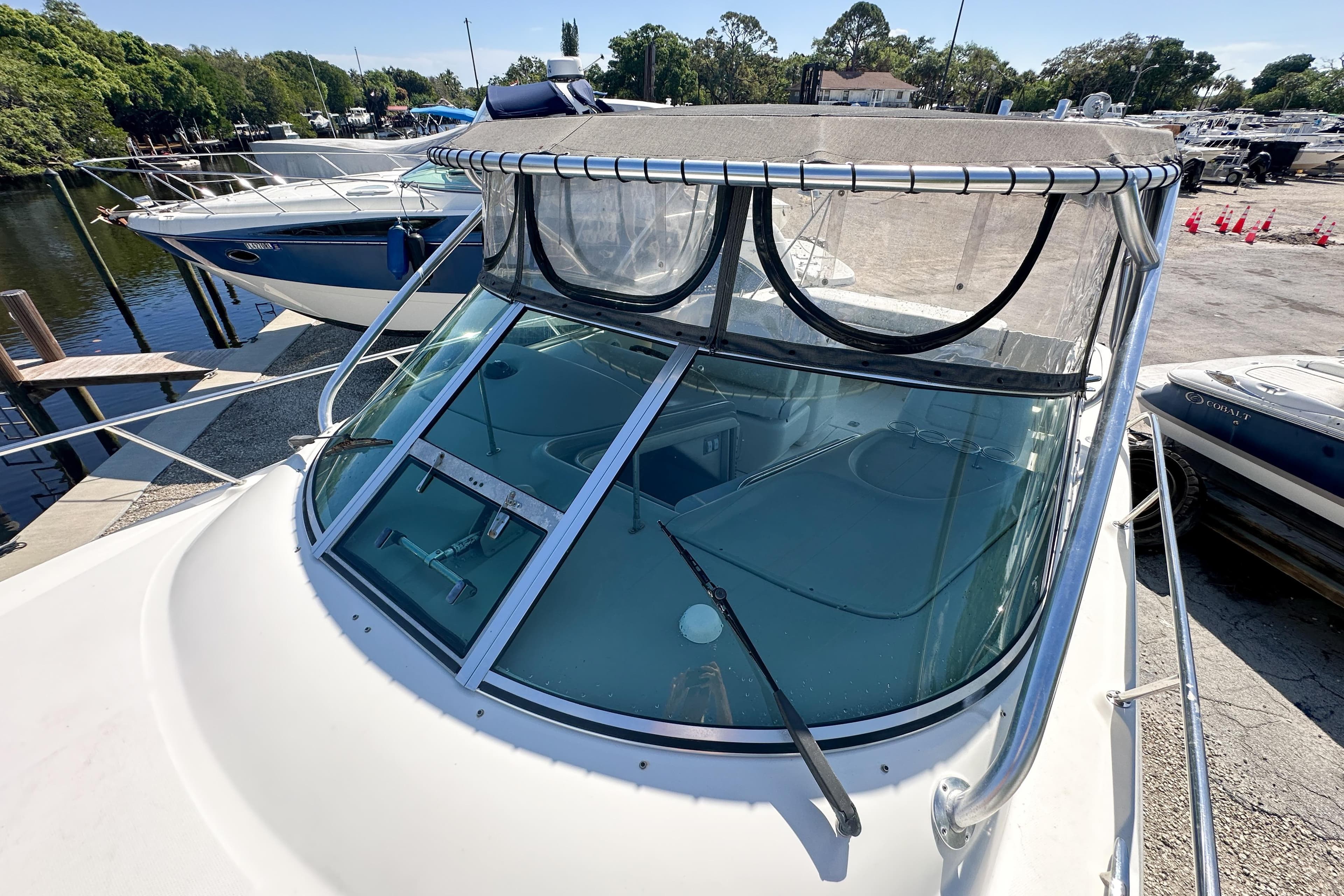 2006 Sea Ray 290 Amberjack boat docked, featuring a clear windshield and canopy.