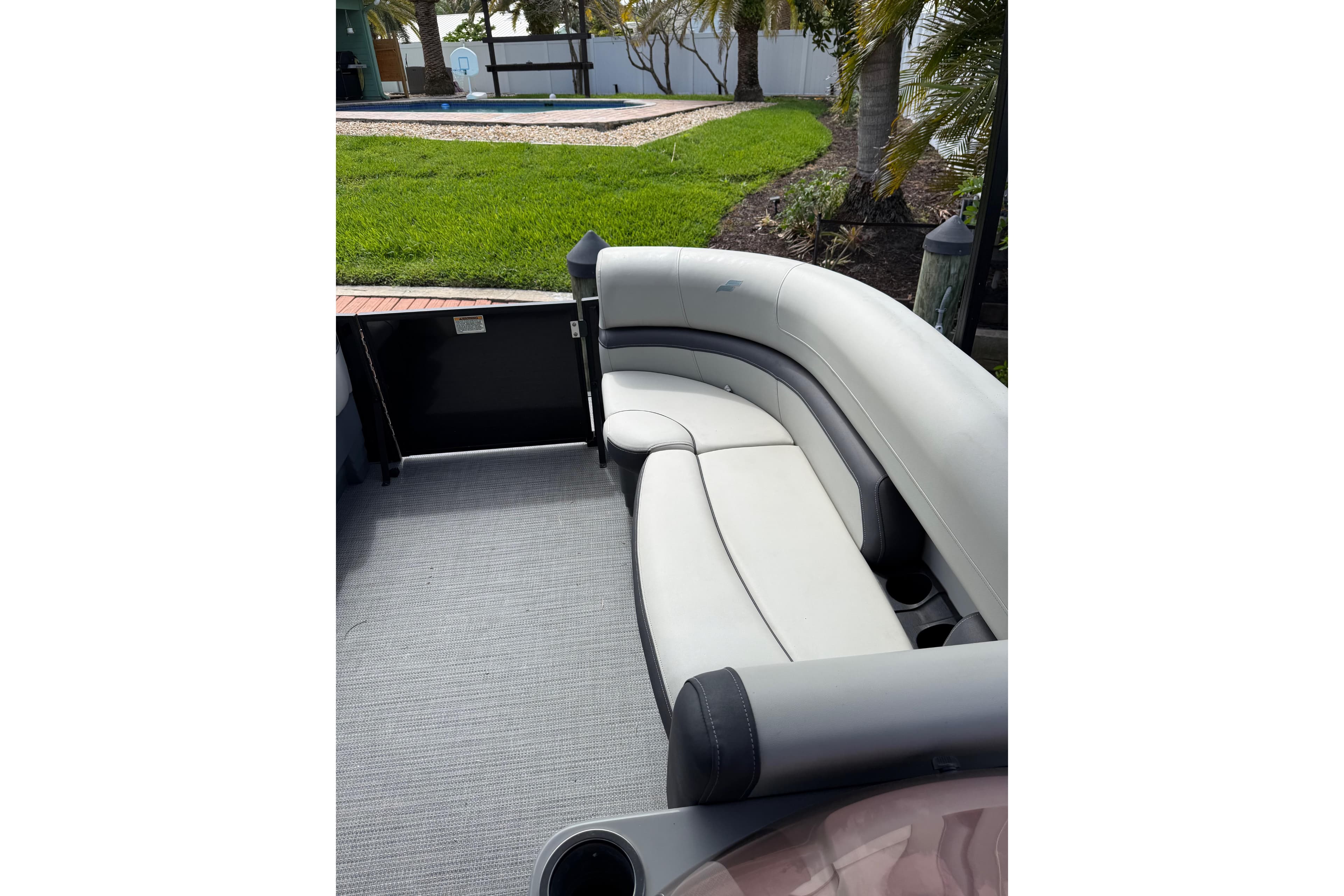 2023 Starcraft EXS 3 Q boat interior with curved seating and lush outdoor view.