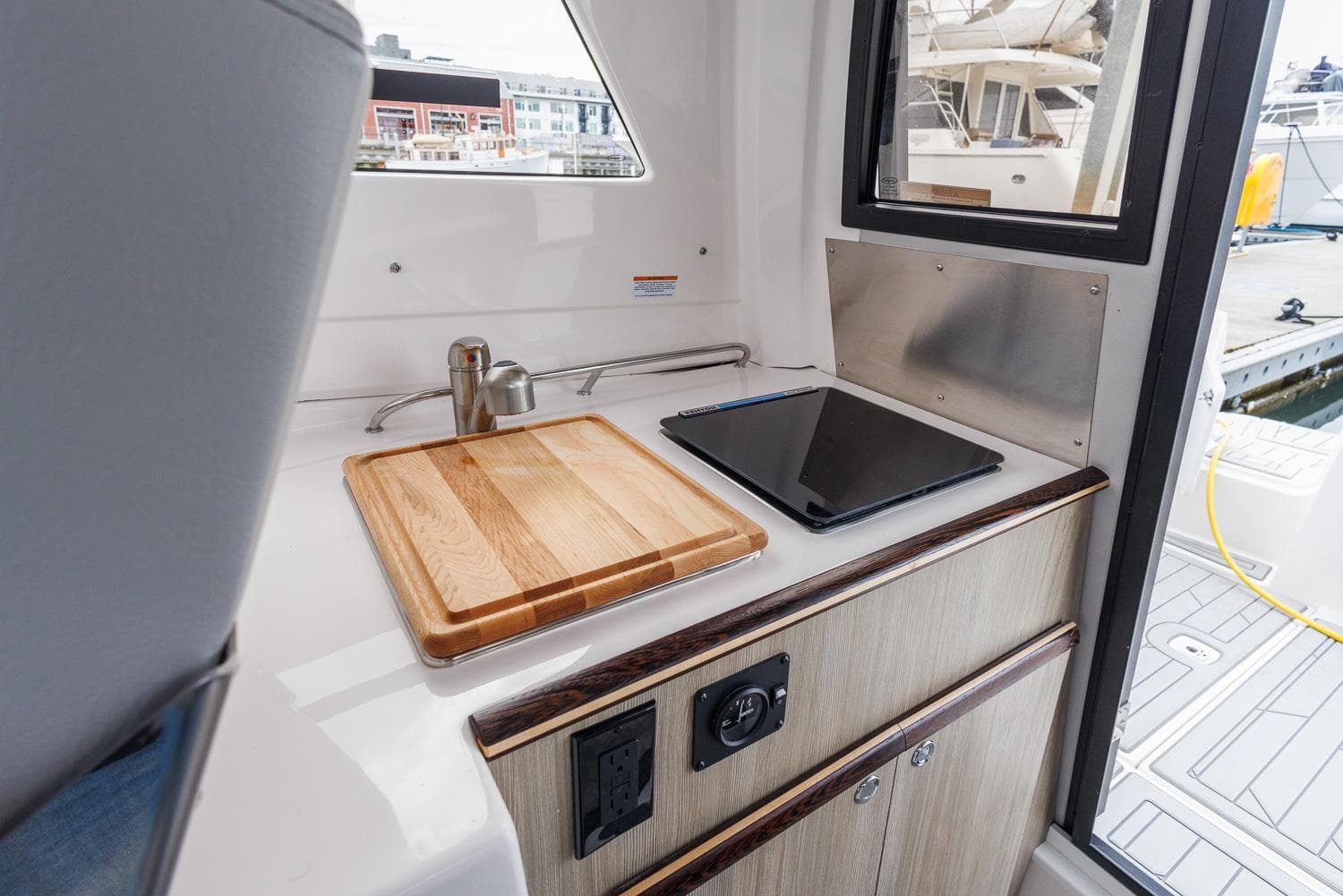 Compact kitchen area in 2026 Solara 250-C boat with sink and cooktop.