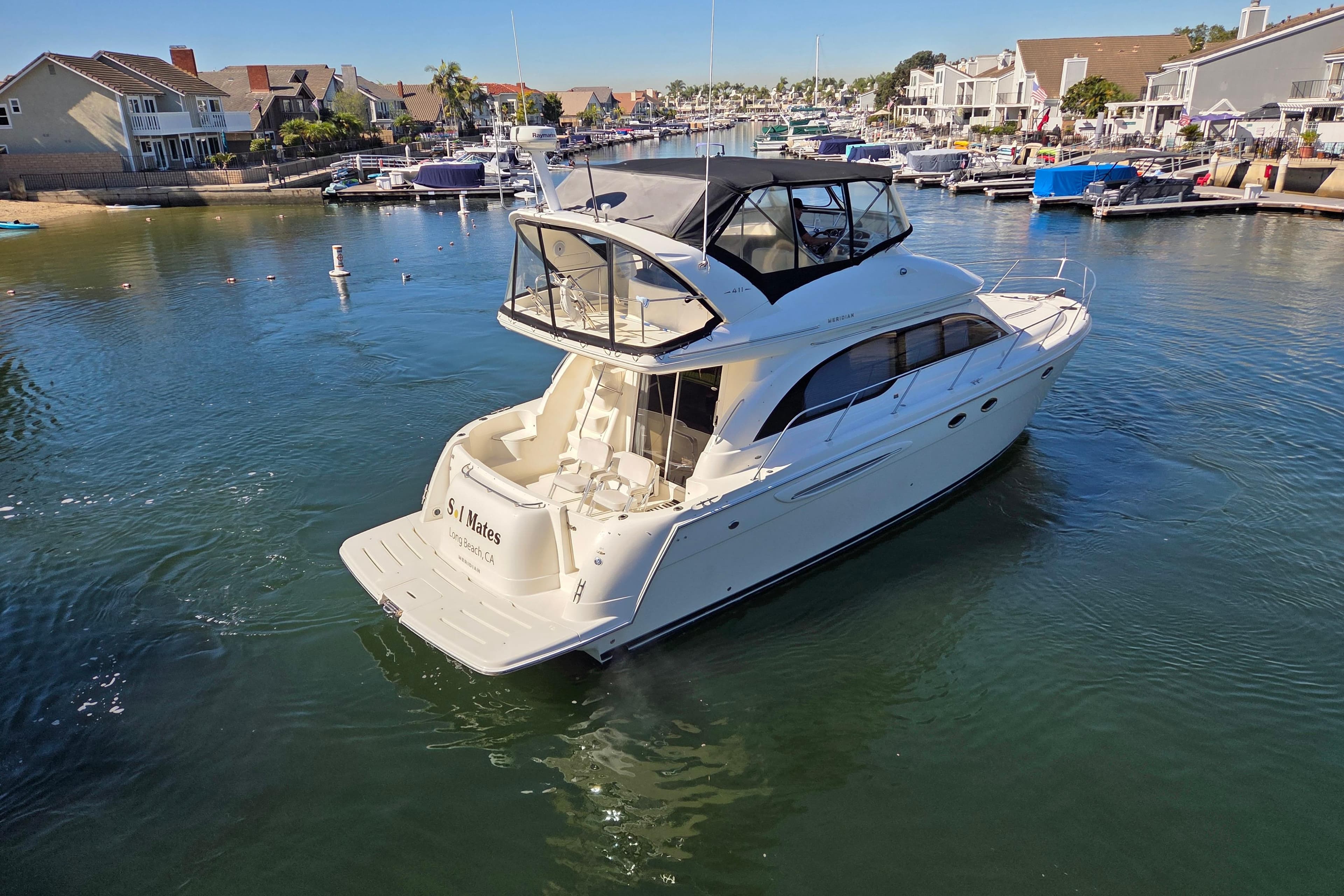 2005 Meridian 411 Sedan yacht cruising in a scenic marina setting.