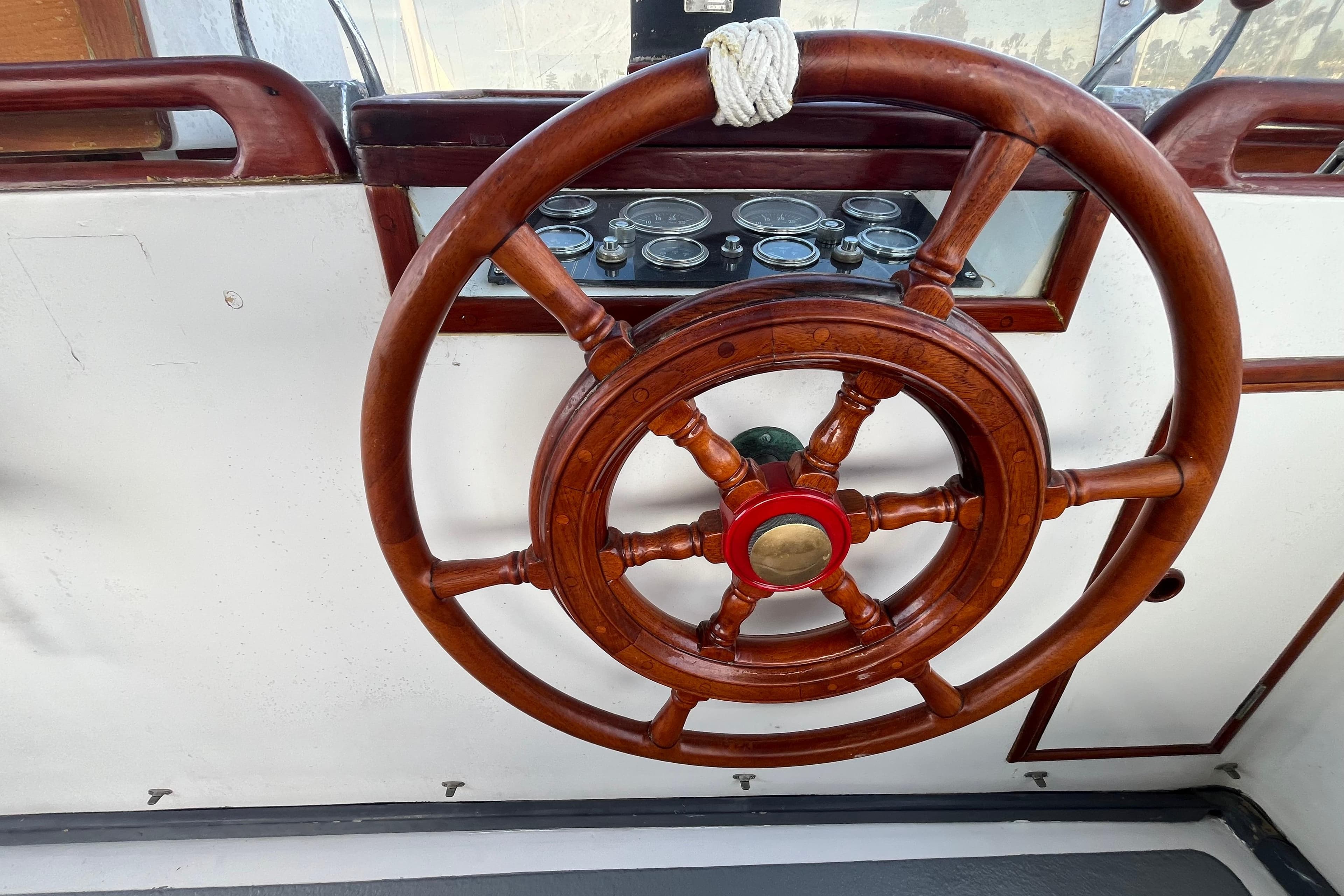 Wooden steering wheel of a 1978 Marine Trader 40 boat, with visible gauges.