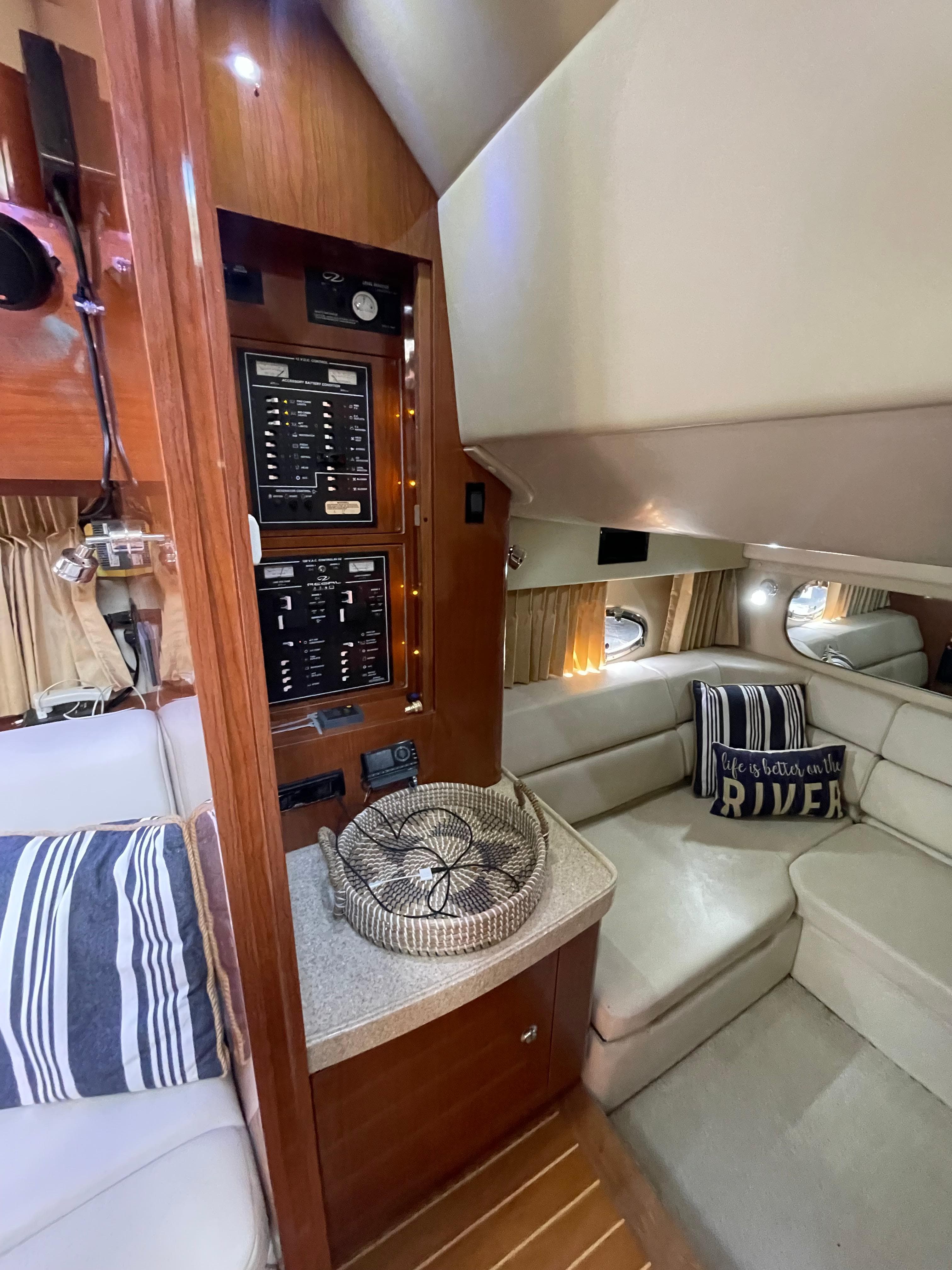 Interior of 2005 Regal Commodore 3560 IB yacht with control panel and cozy seating area.