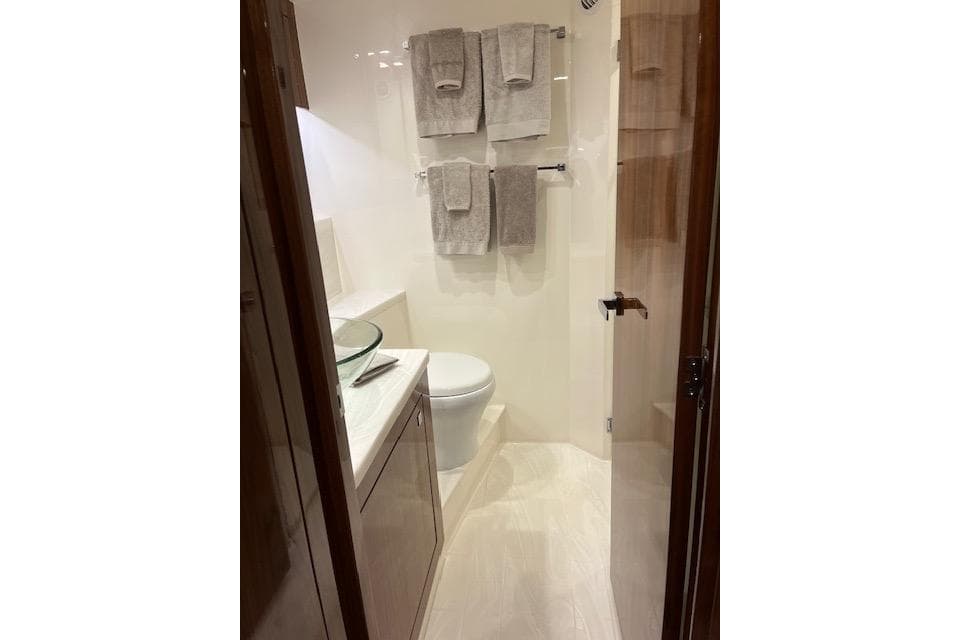 Luxurious bathroom in 2023 Riviera 5400 Sport Yacht with modern fixtures and elegant design.