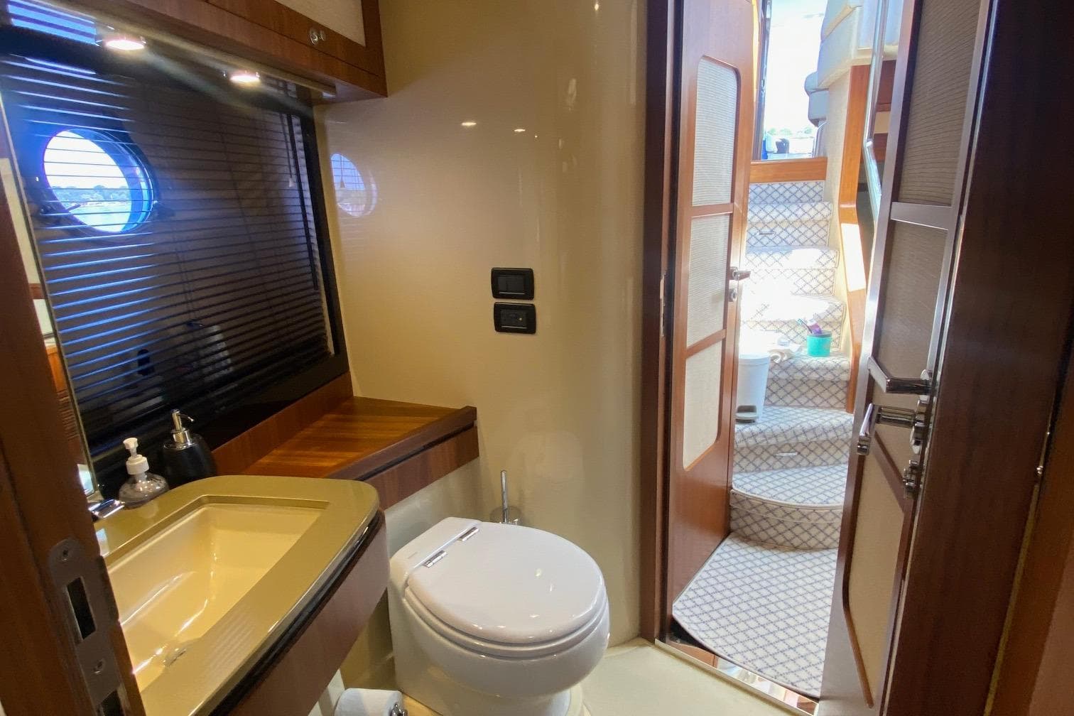 Luxurious bathroom on 2014 Azimut Magellano 50 yacht with modern fixtures and wooden accents.