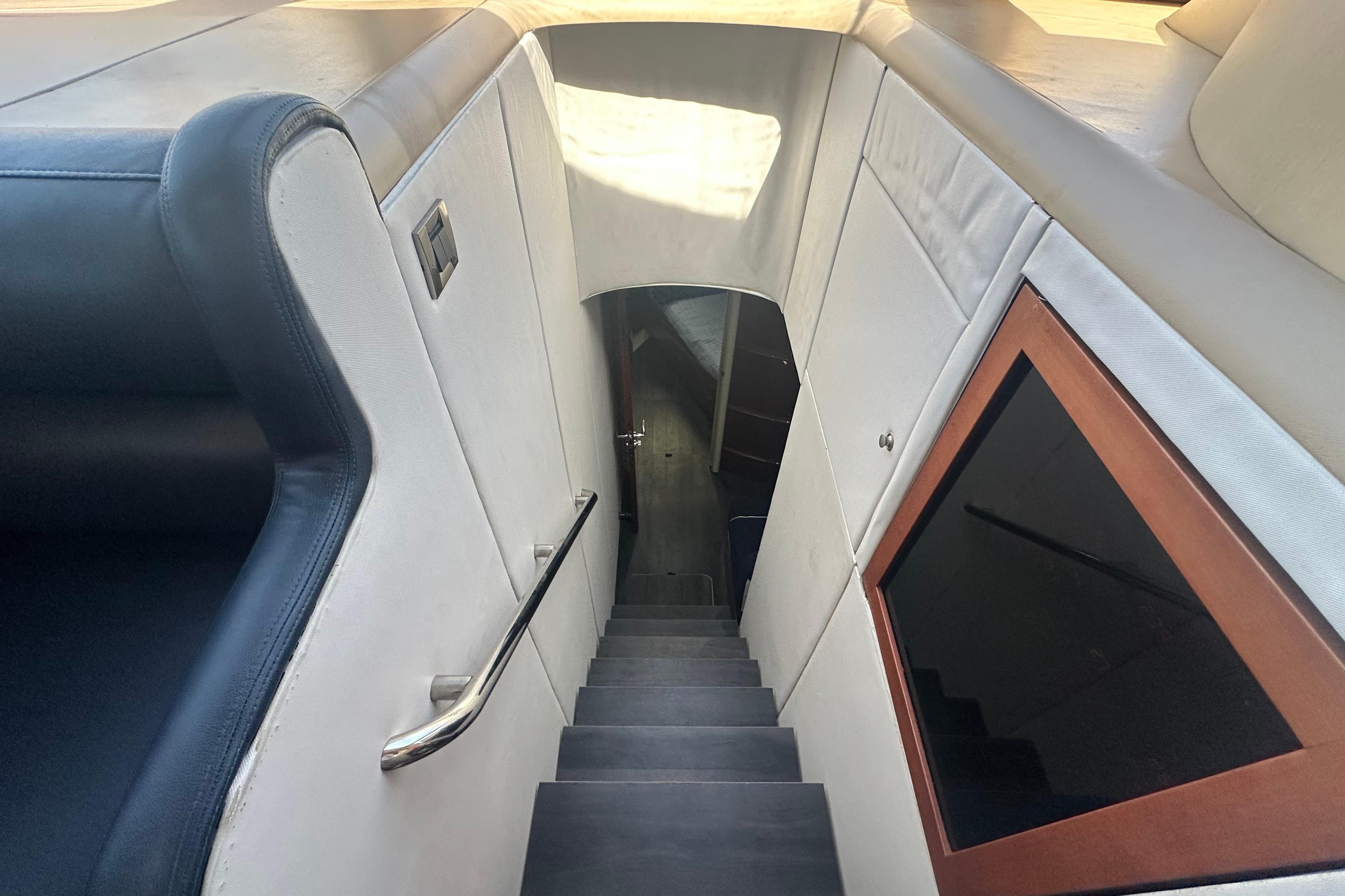 Interior staircase of 2006 Lazzara 68 Motoryacht, featuring sleek design and modern finishes.