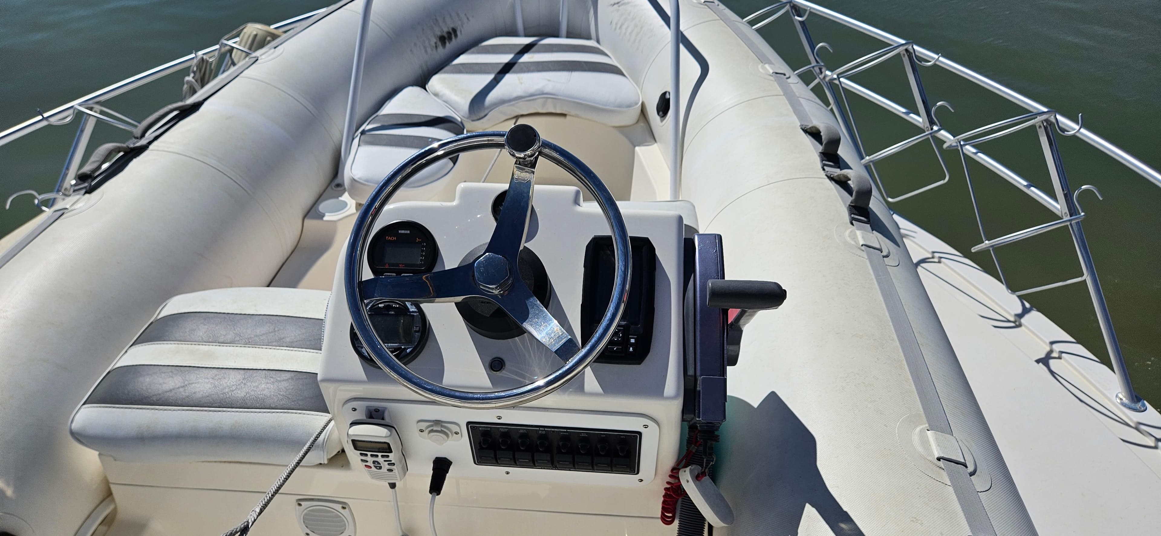 1995 Bertram Convertible boat interior with steering wheel and seating, on calm water.