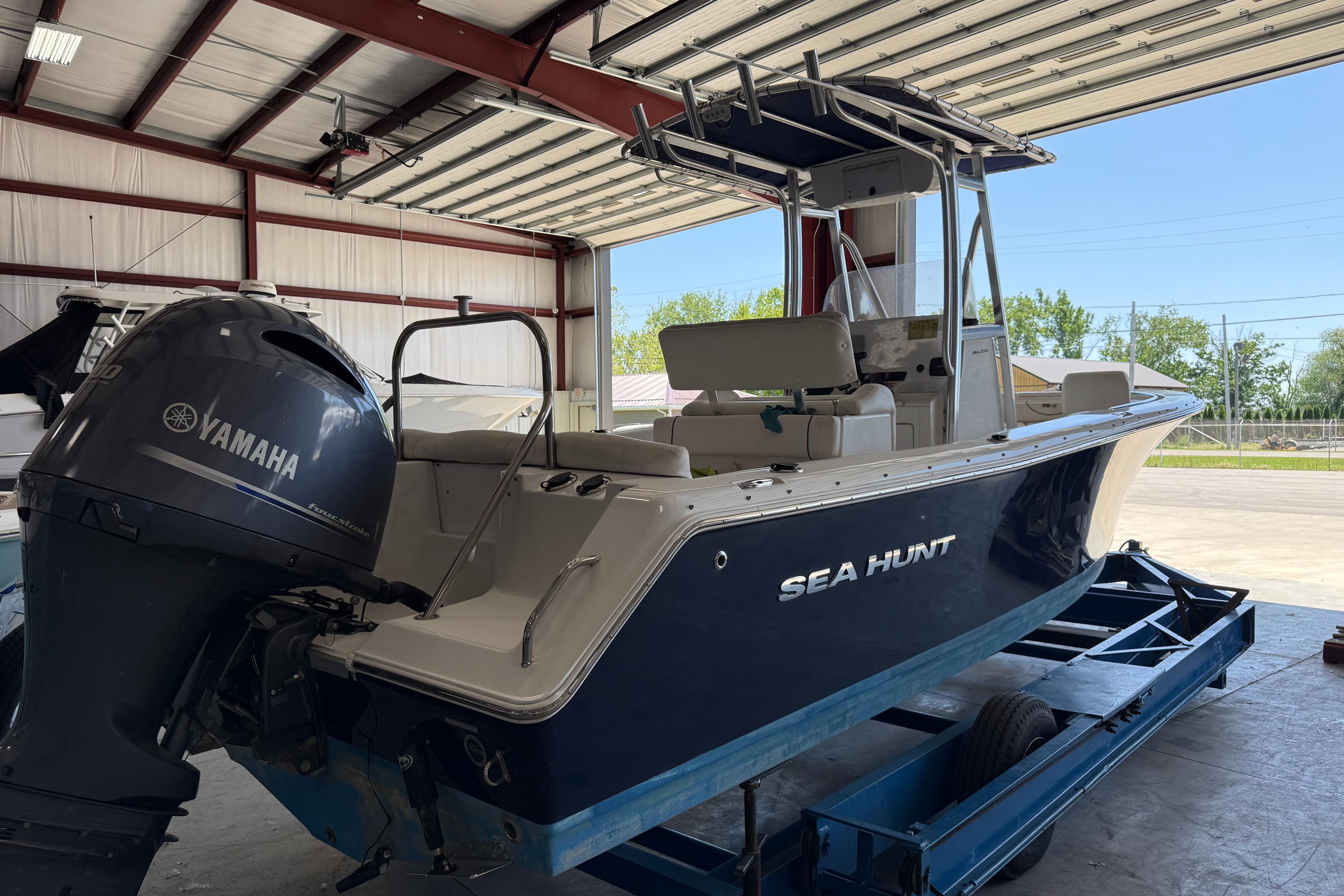 2015 Sea Hunt Ultra 234 boat with Yamaha engine in a garage setting.