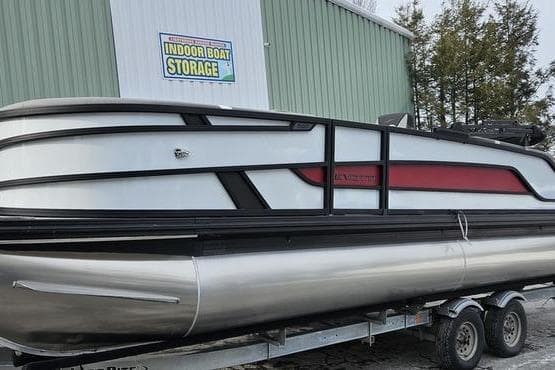2026 Evotti 523QL pontoon boat on trailer near indoor storage facility.