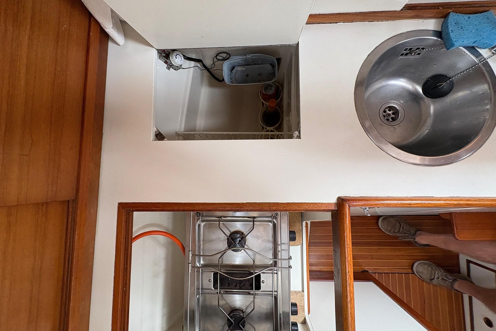 Interior of 1973 Wauquiez Centurion 32 yacht with stove, sink, and wooden flooring.