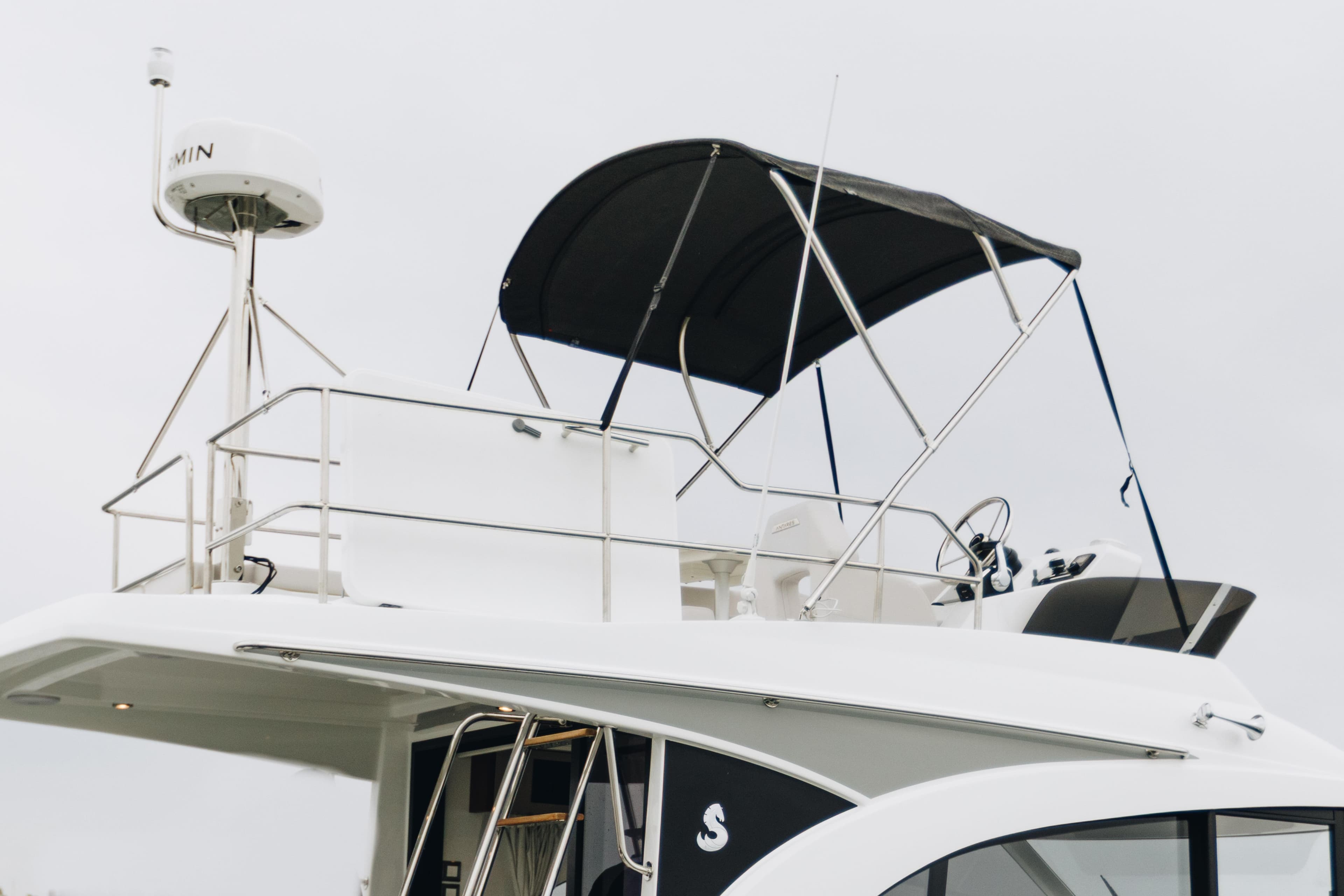 2026 Beneteau Antares 11 Flybridge with radar and canopy, side view.