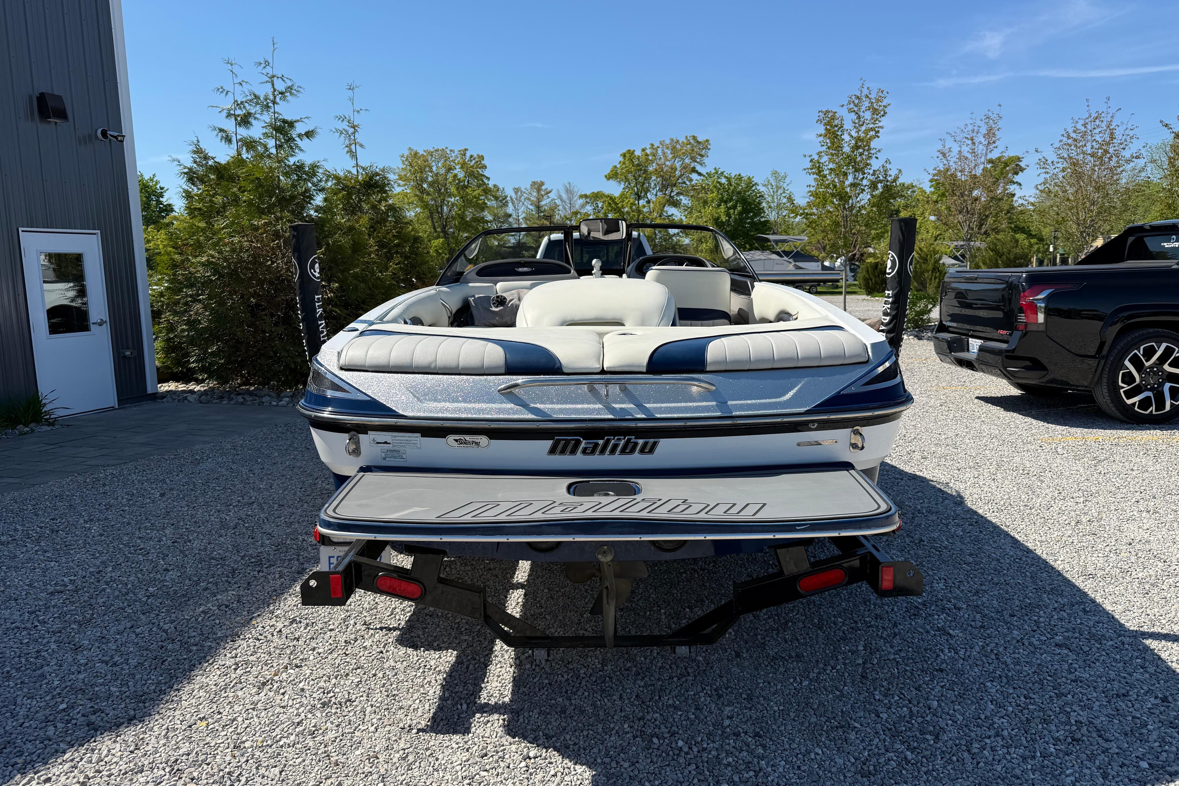 2015 Malibu Response TXi boat on trailer, parked outdoors on gravel.