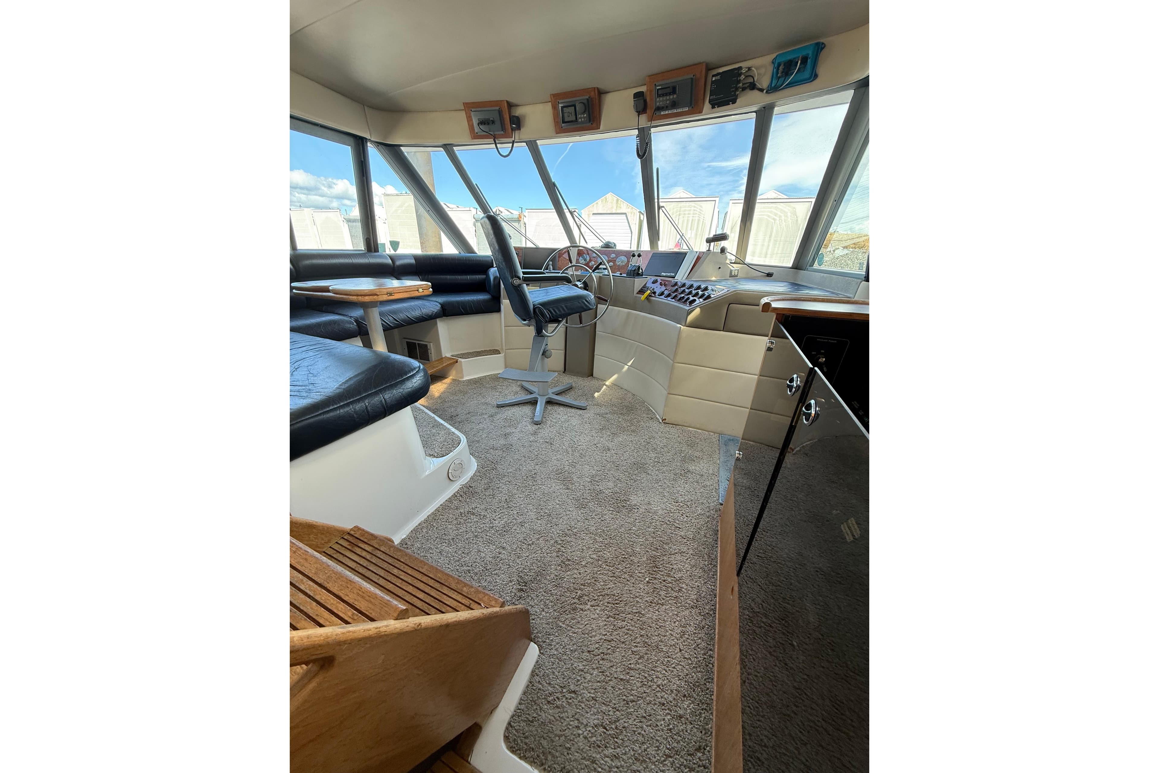 Interior of 1997 Bayliner 47 Motoryacht with helm, seating, and panoramic windows.