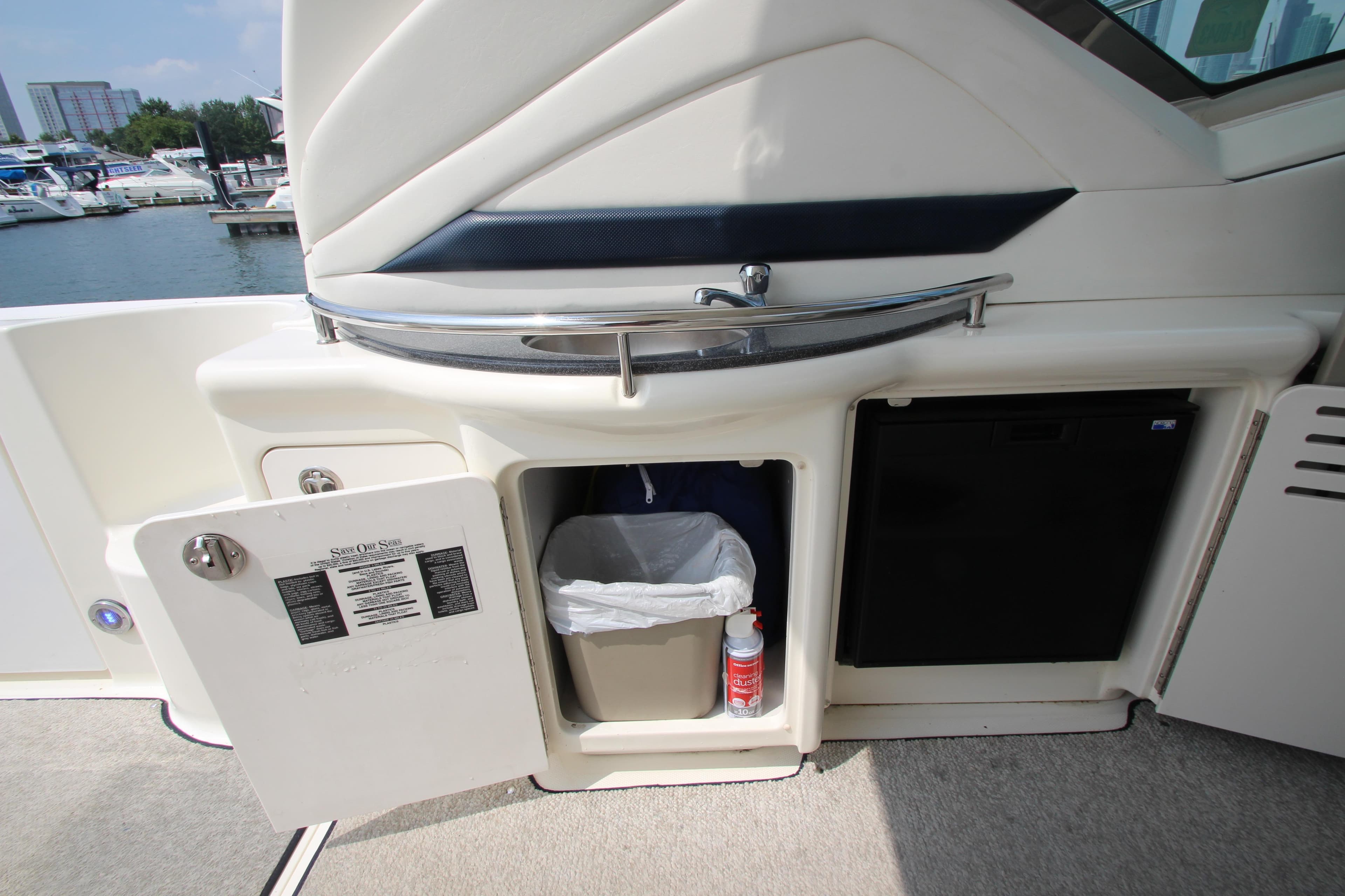 2004 Sea Ray 40 Sundancer yacht interior with open storage compartment and mini fridge.