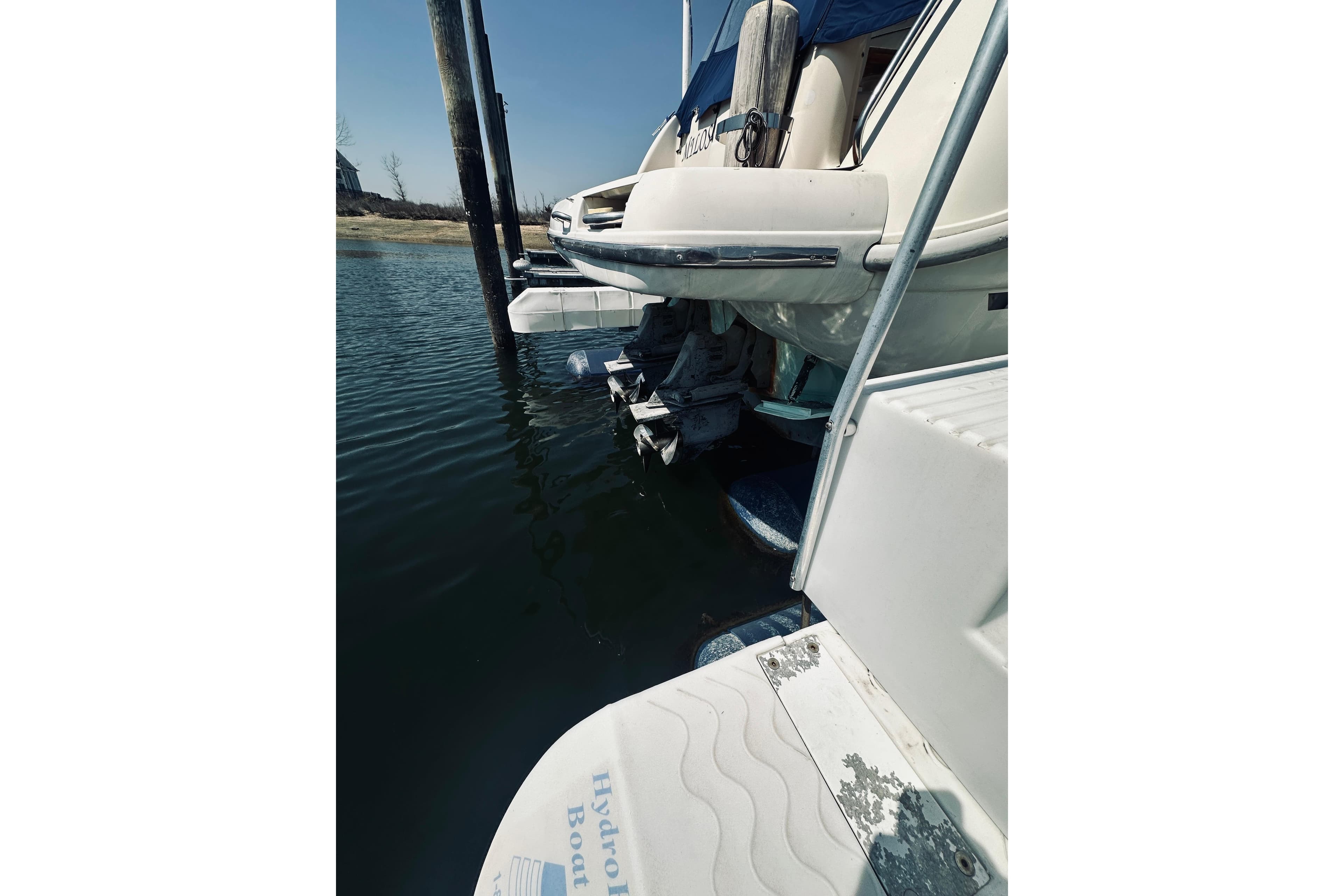1999 Cranchi Zaffiro 34 boat docked, showing stern and outboard motor in water.