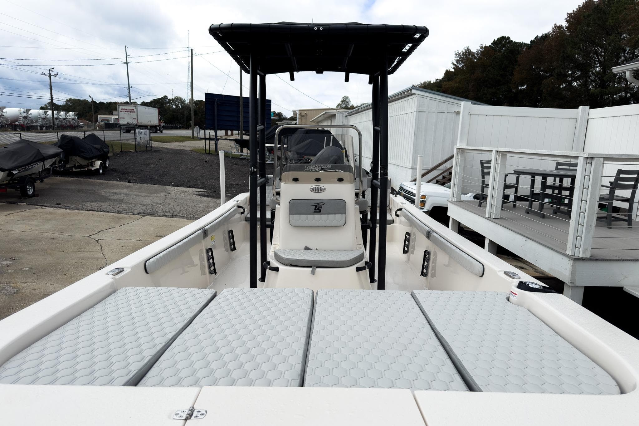 2026 Carolina Skiff 21 LS boat with T-top and cushioned seating, docked outdoors.