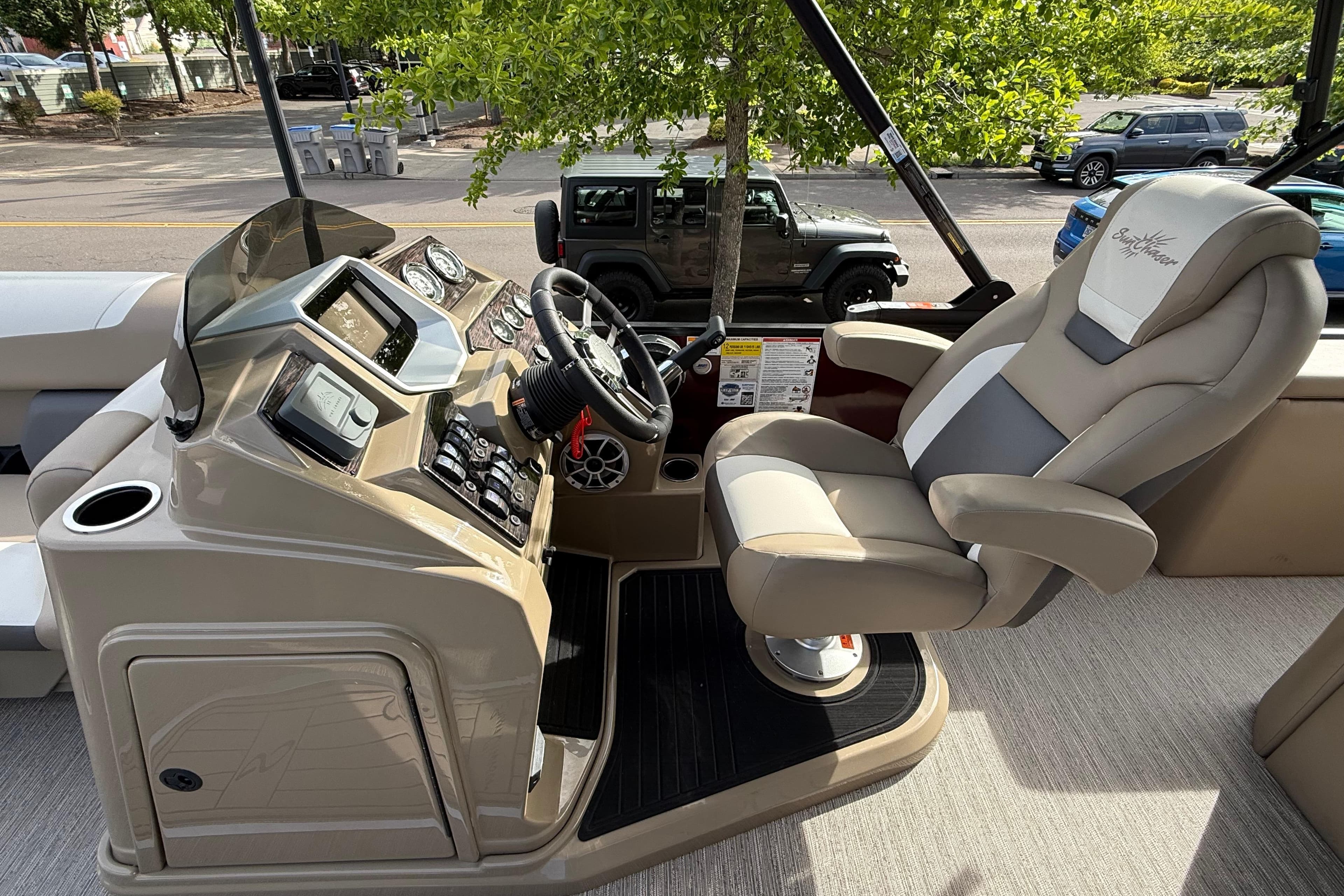 Captain's helm of 2026 SunChaser Eclipse 23 SB DH pontoon boat, featuring modern controls and plush seating.