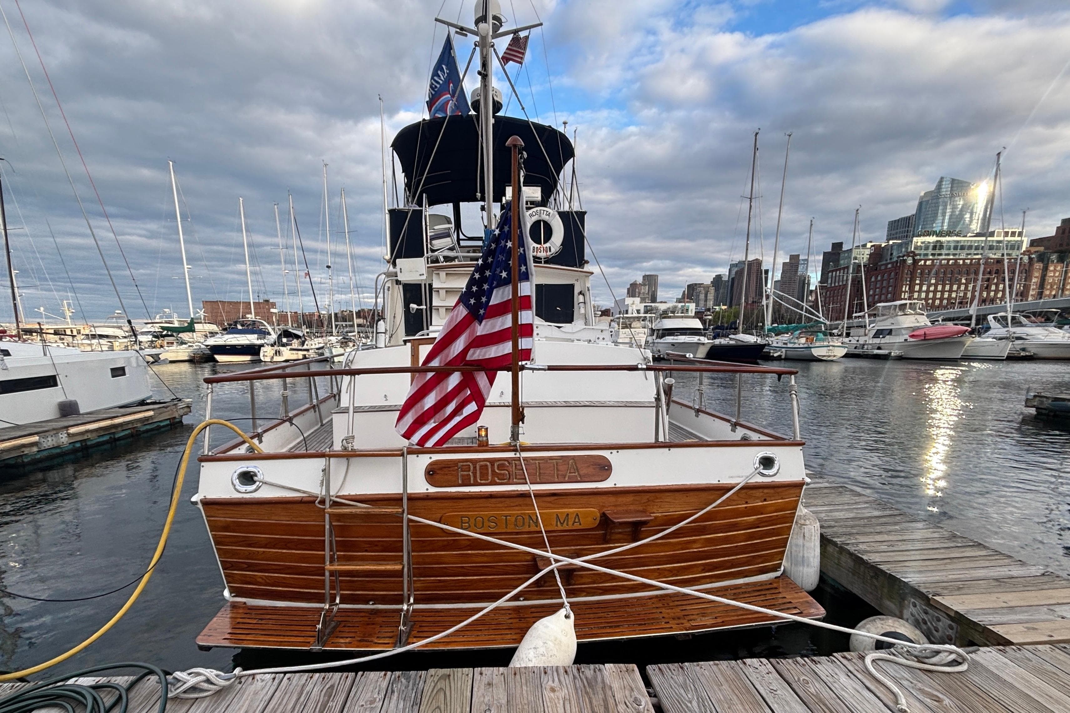 1987 Grand Banks 42 Classic yacht docked in a marina with city skyline.