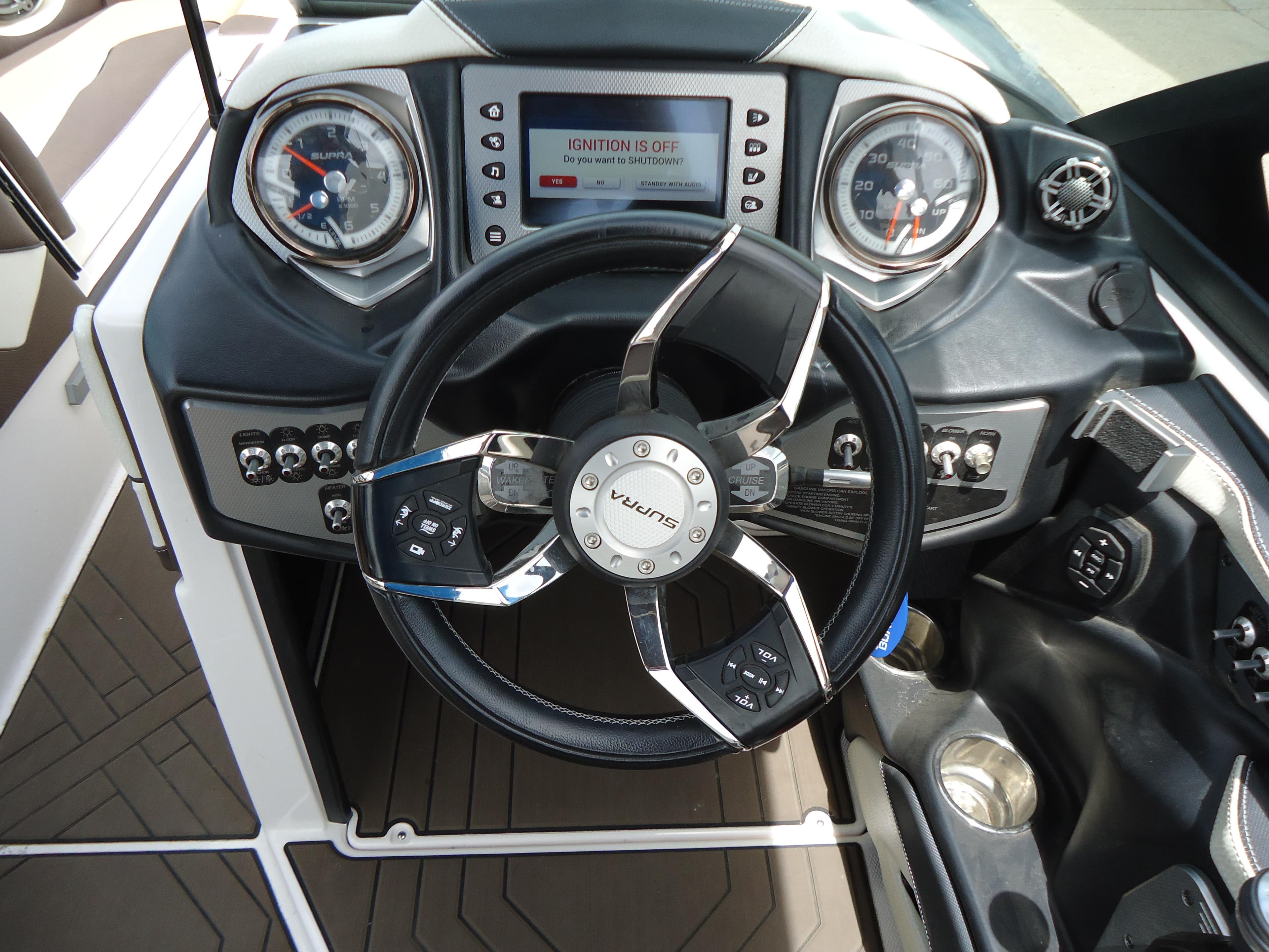 2018 Supra SL boat dashboard with steering wheel and control panel.