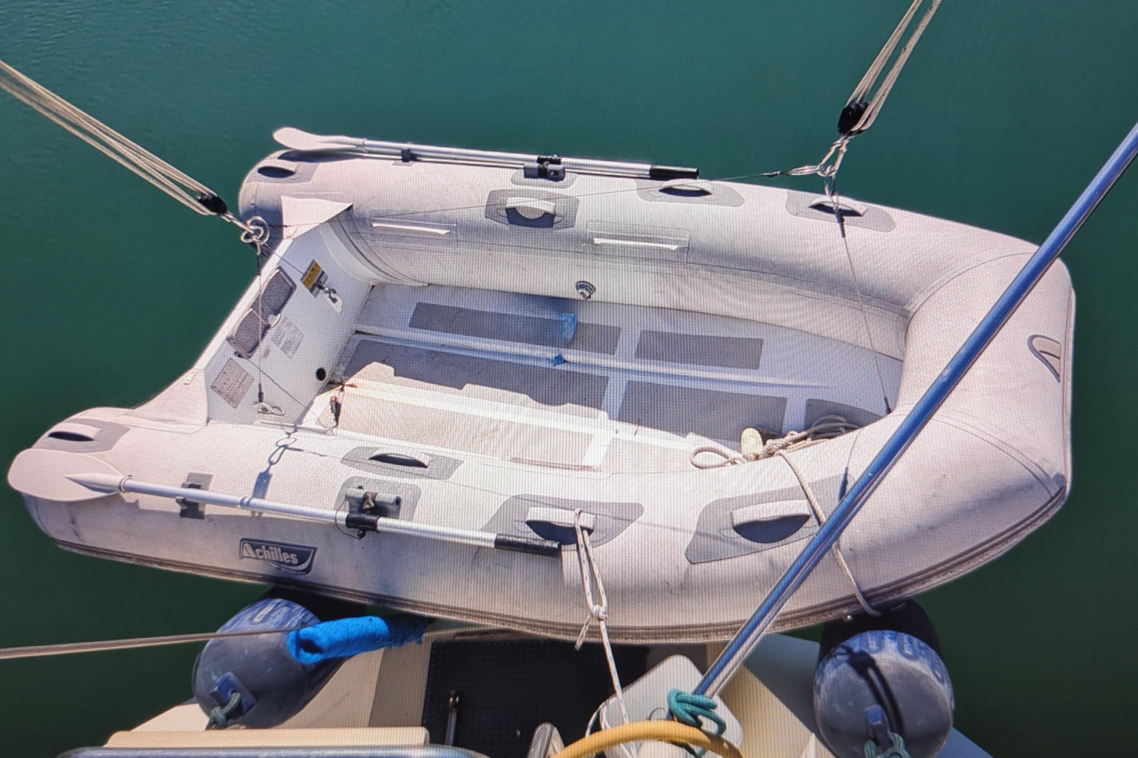 Inflatable dinghy on a 1990 Catalina 42 sailboat, secured with ropes.