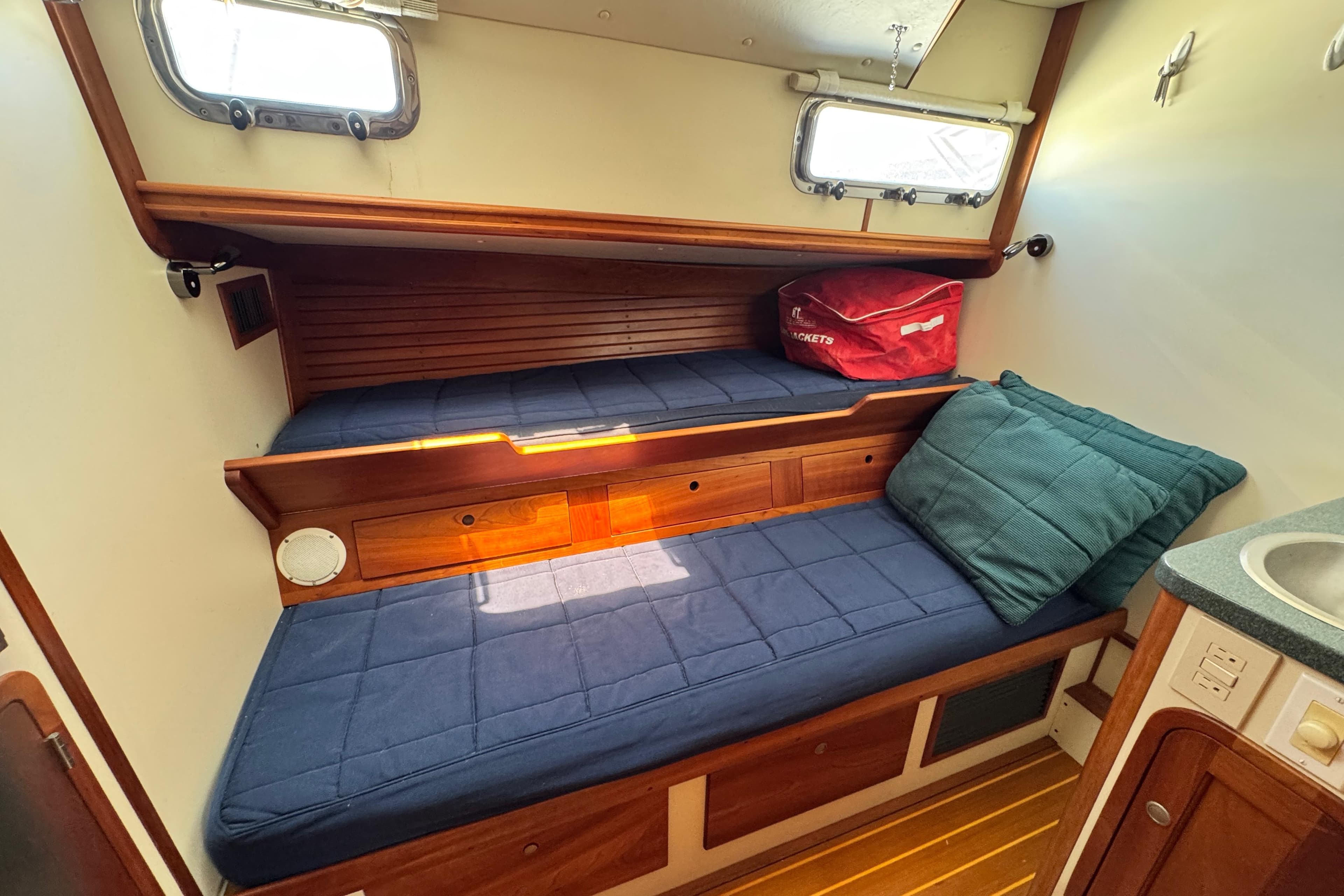 1999 Legacy Yachts 40 Downeast cabin with blue cushions and wooden interior.