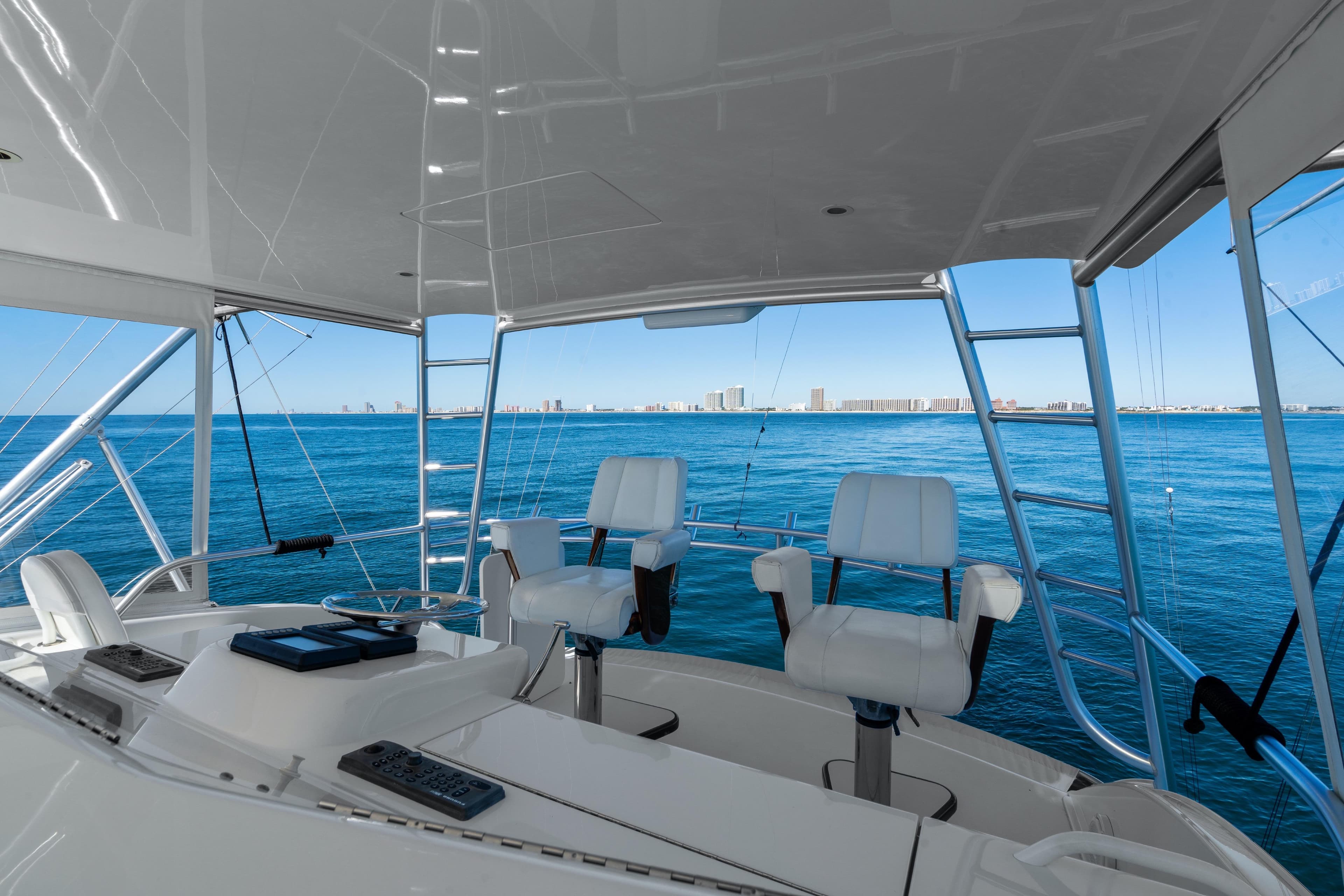 Helm of 2007 Viking 56 Convertible yacht with ocean view and city skyline.