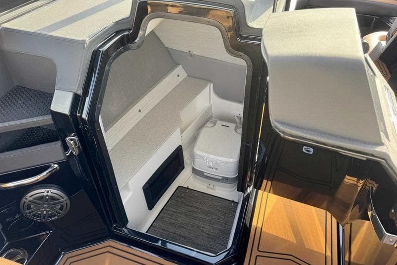 2026 Cobalt R8 Surf boat interior with seating and compact toilet.