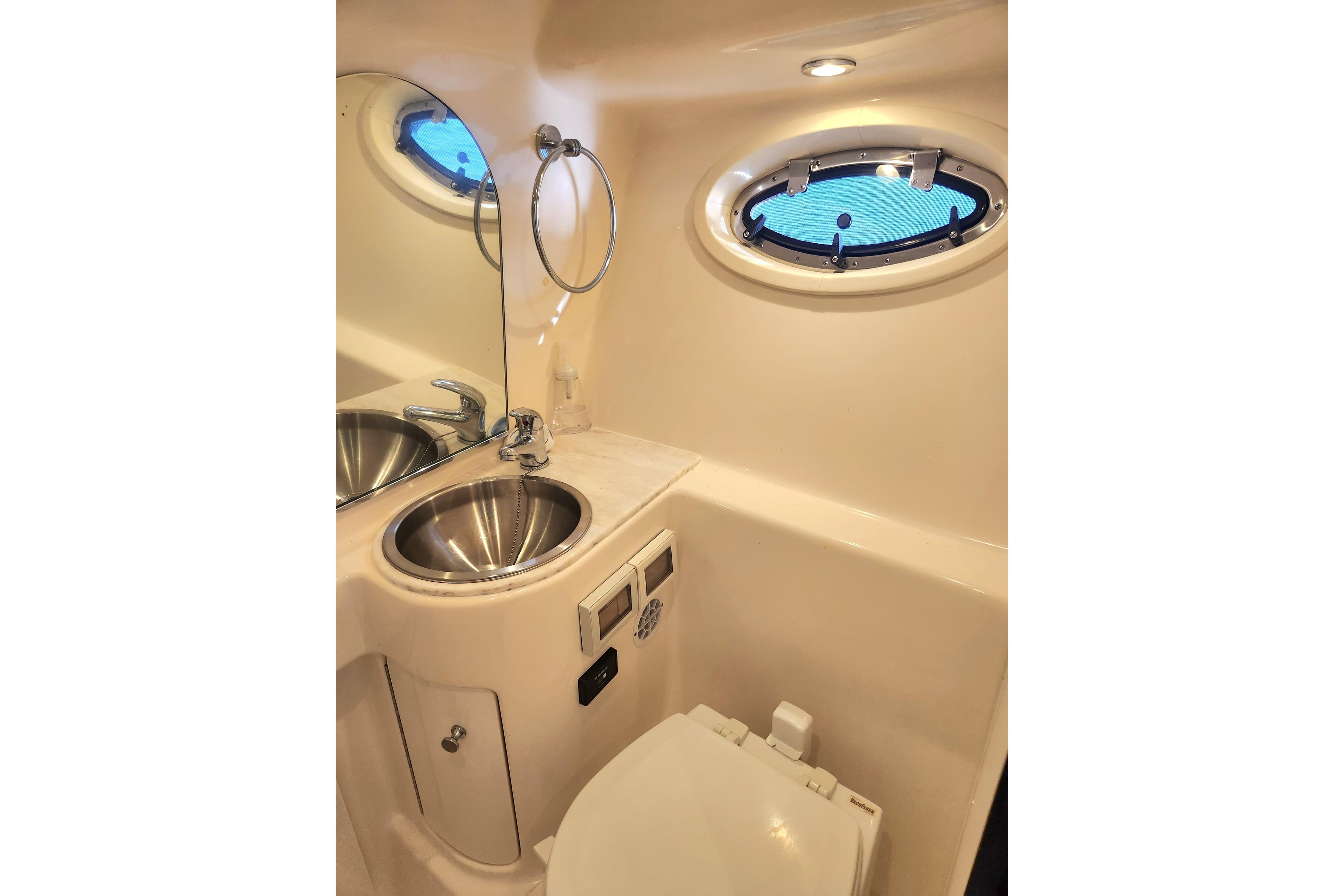 Luxurious 2014 Tiara Yachts 3100 Coronet bathroom with stainless steel sink and porthole window.