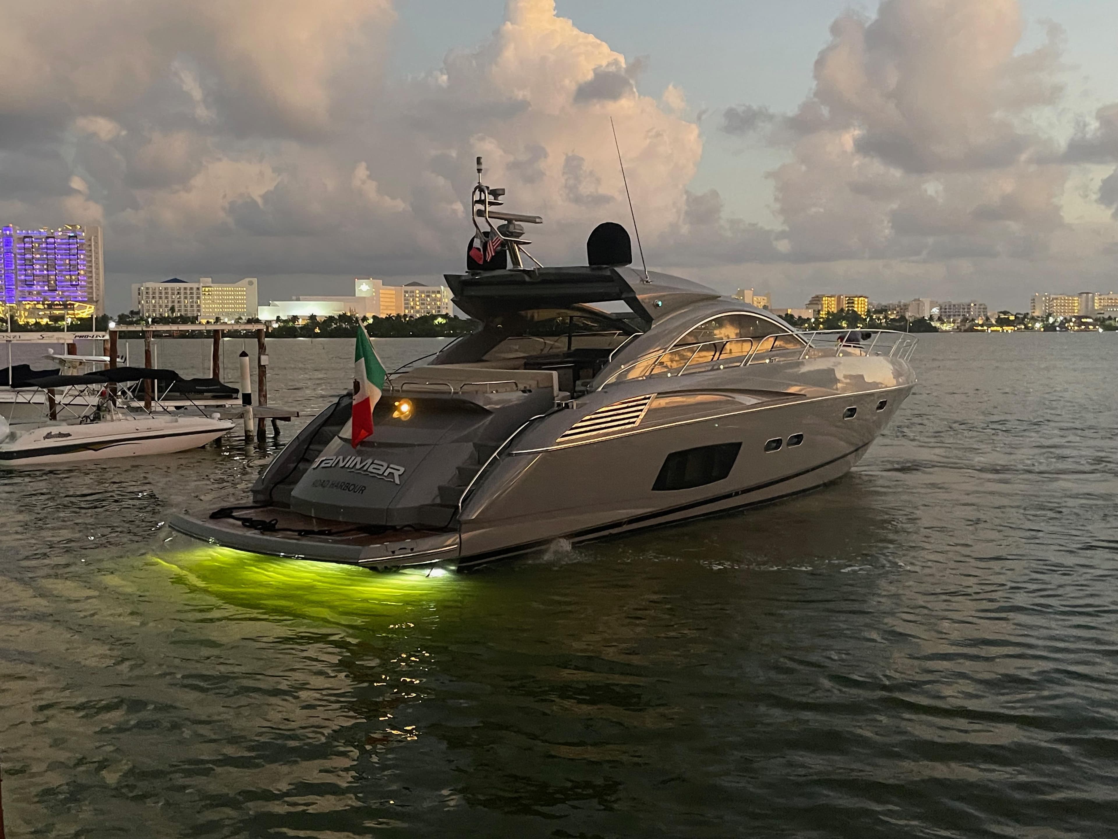 2011 Sunseeker Predator 60 yacht with glowing lights, docked at sunset.