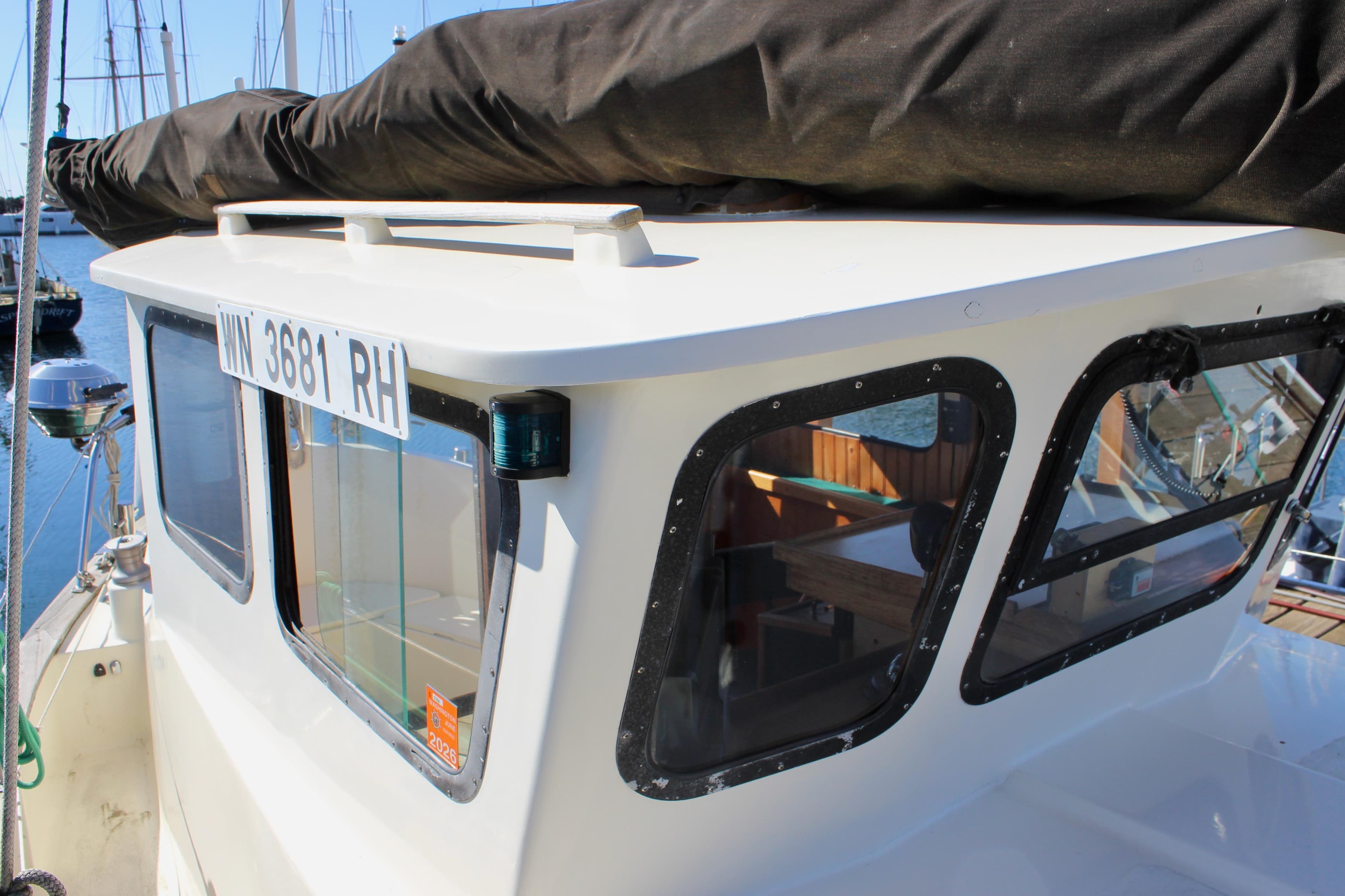 1972 Fisher 30 boat cabin with registration number, docked in a marina.