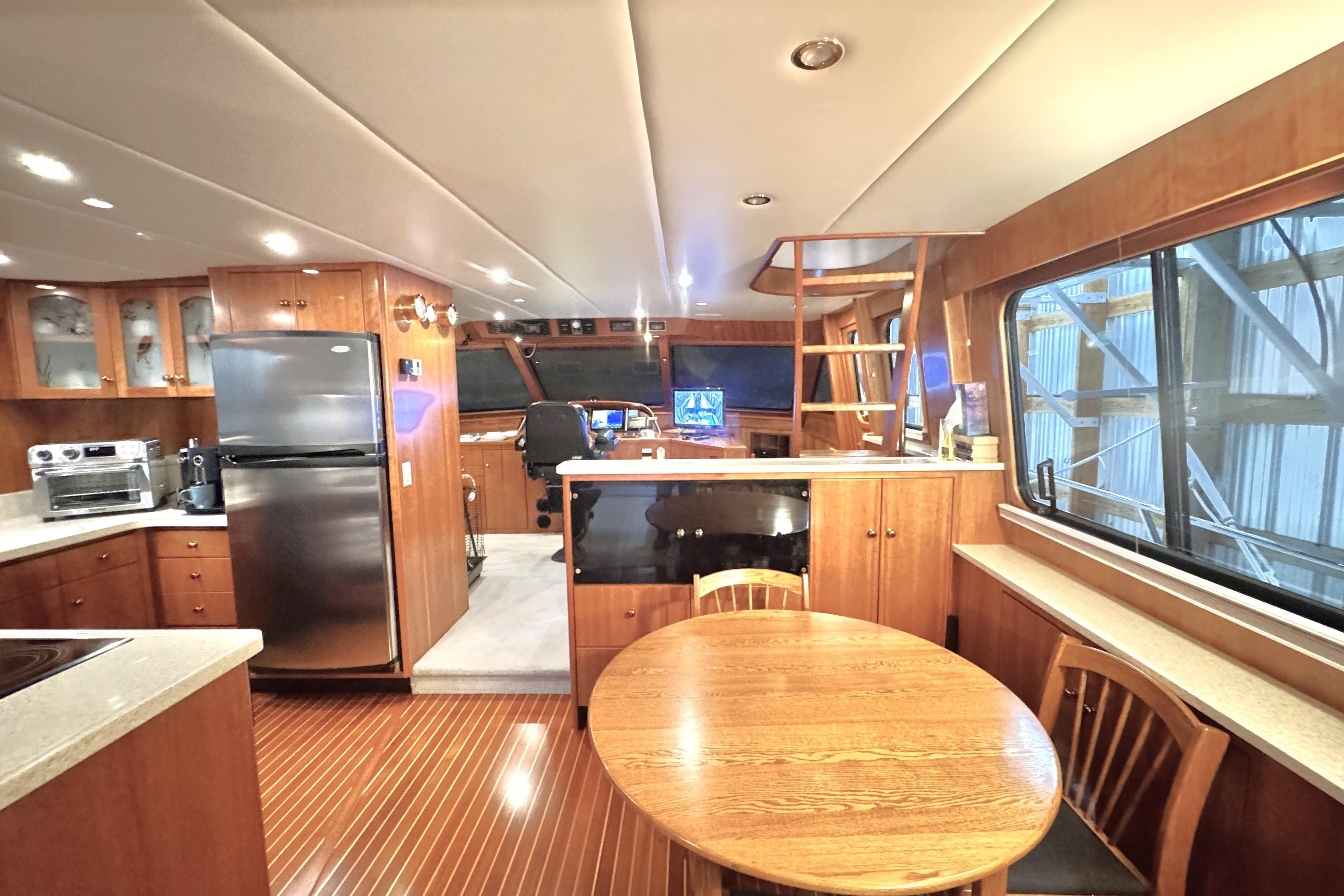 Luxurious interior of 1999 Wendon 73 Skylounge yacht with modern kitchen and dining area.