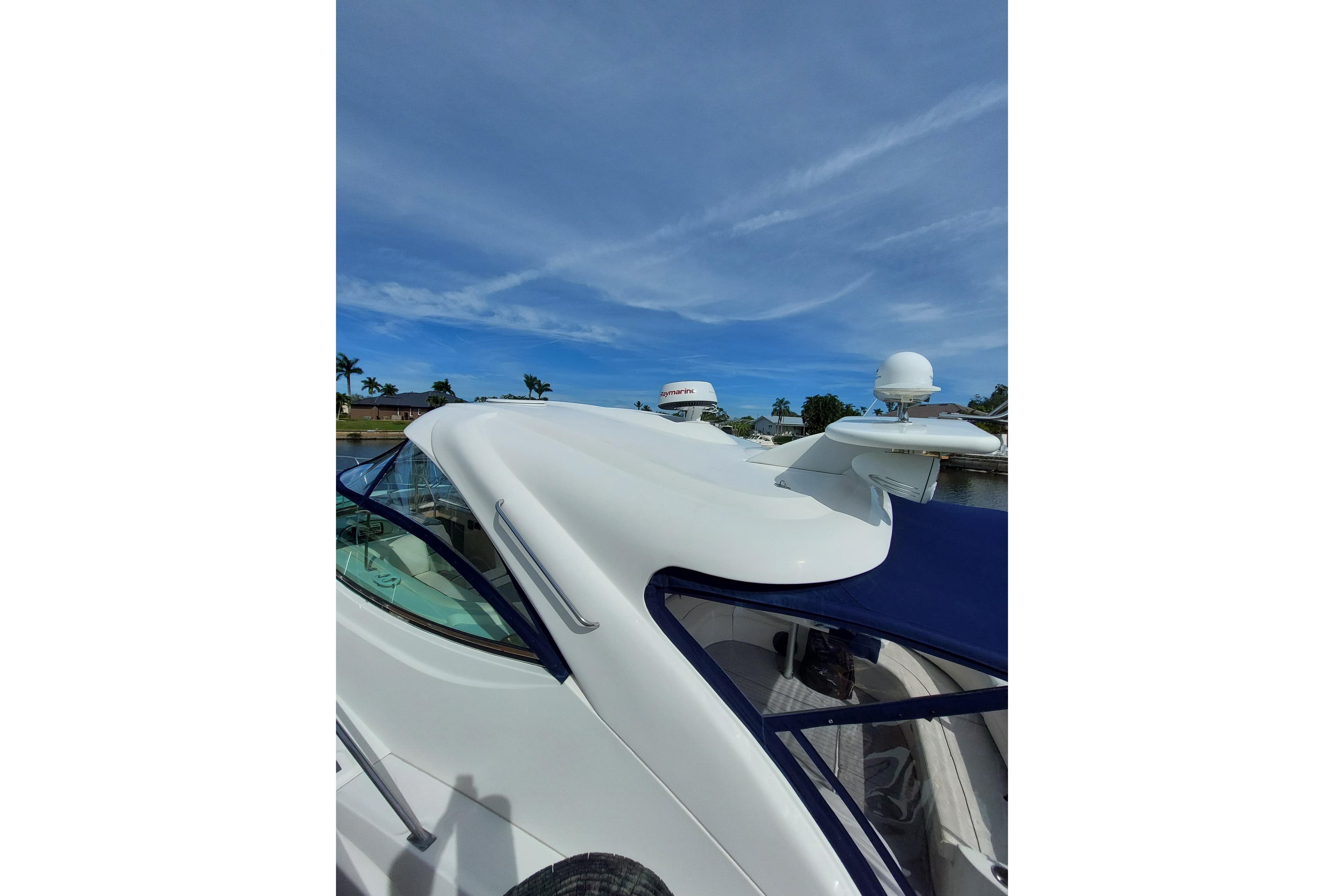 2006 Cruisers Yachts 520 Express, sleek design, docked under clear blue sky.