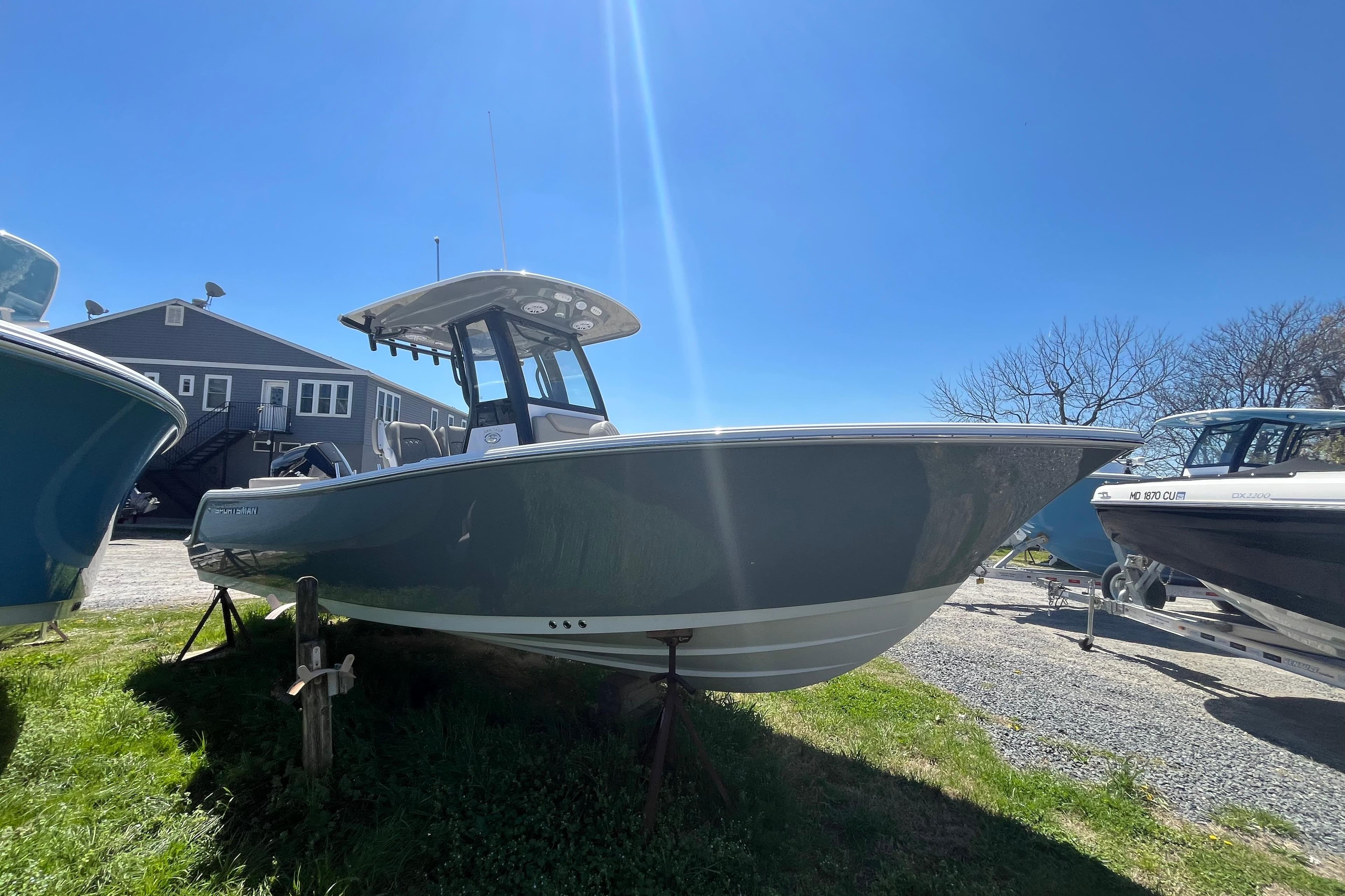 2026 Sportsman Heritage 231 Center Console boat displayed outdoors under clear blue sky.