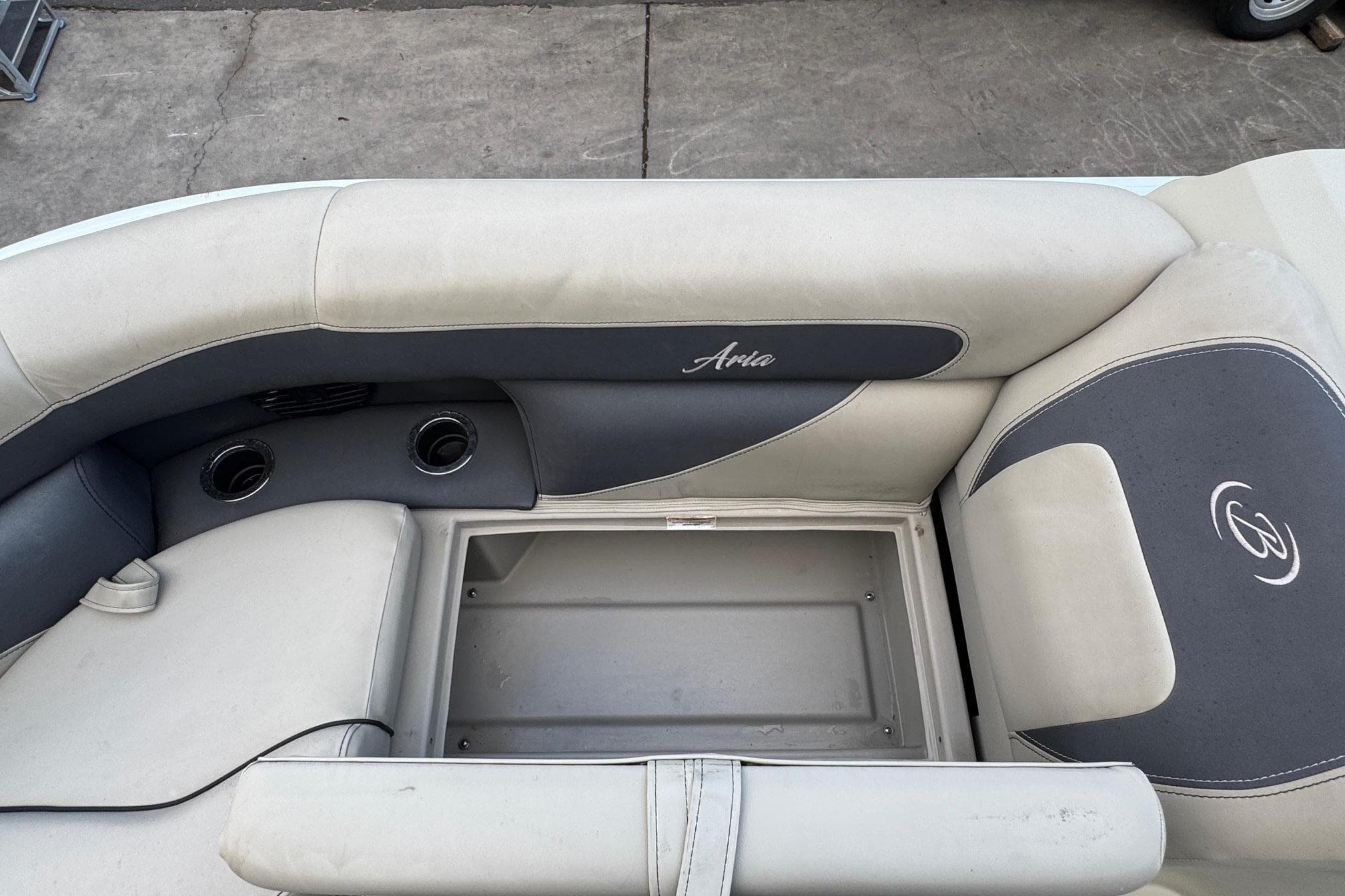 2023 Barletta ARIA 22QC boat interior with storage compartment and cushioned seating.