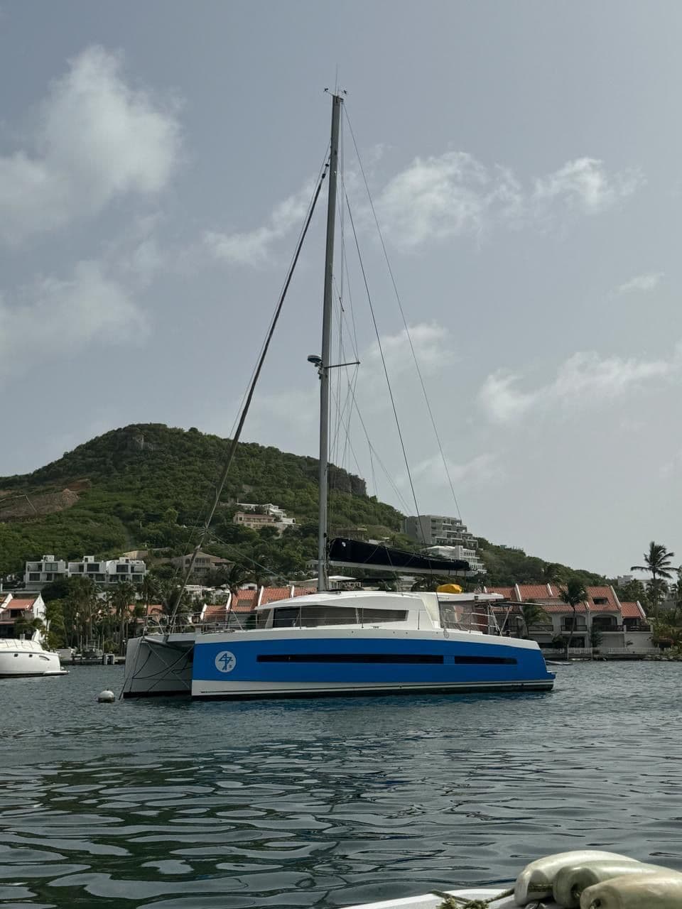 2015 Bali 4.5 catamaran docked in harbor with hillside backdrop.