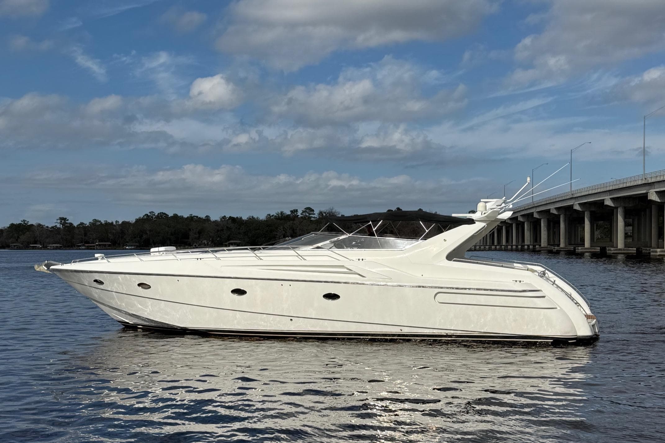 1994 Sunseeker Camargue 55 yacht on calm water near a bridge.