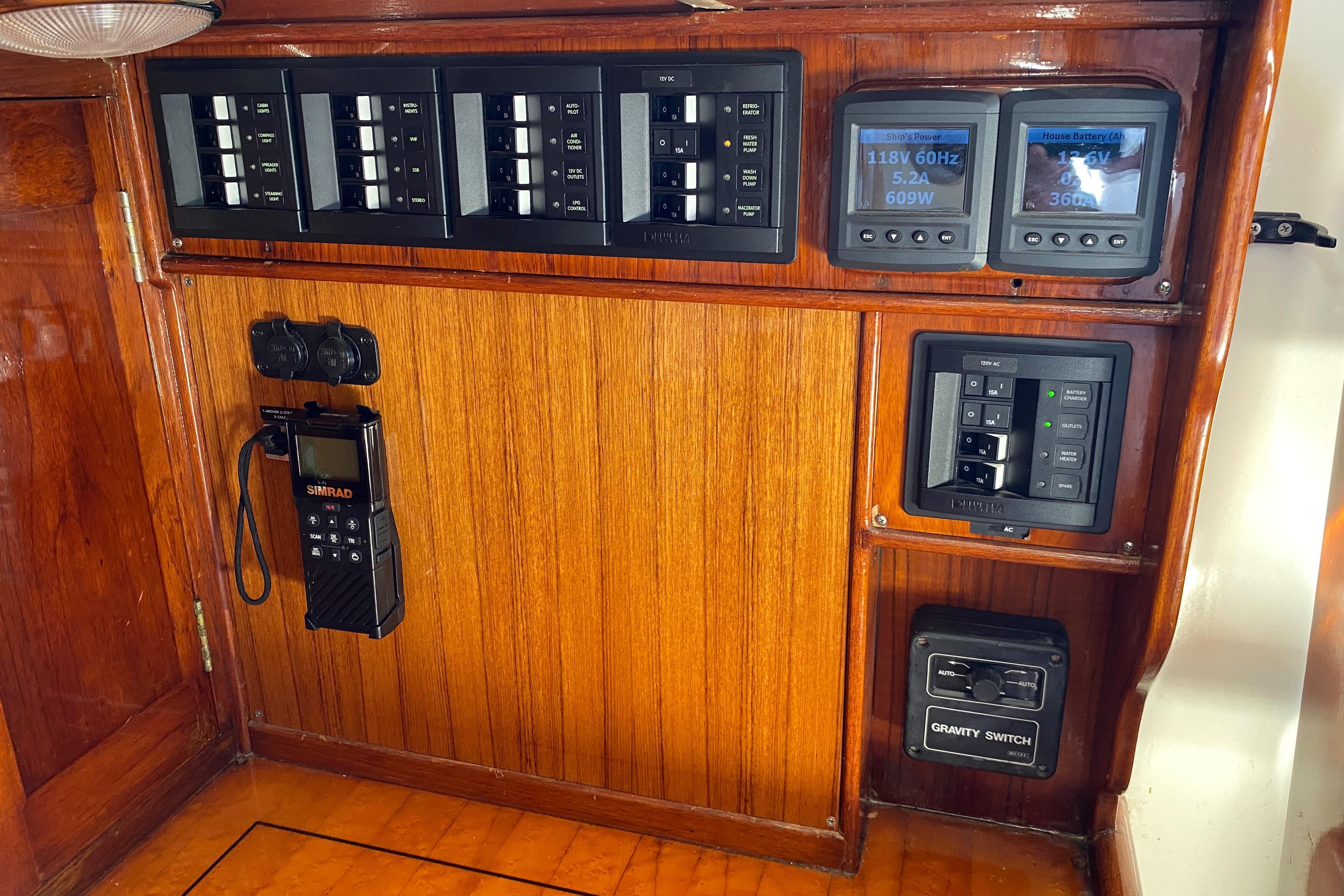 Electrical control panel on a 1962 Cheoy Lee Custom yacht with wood finish.