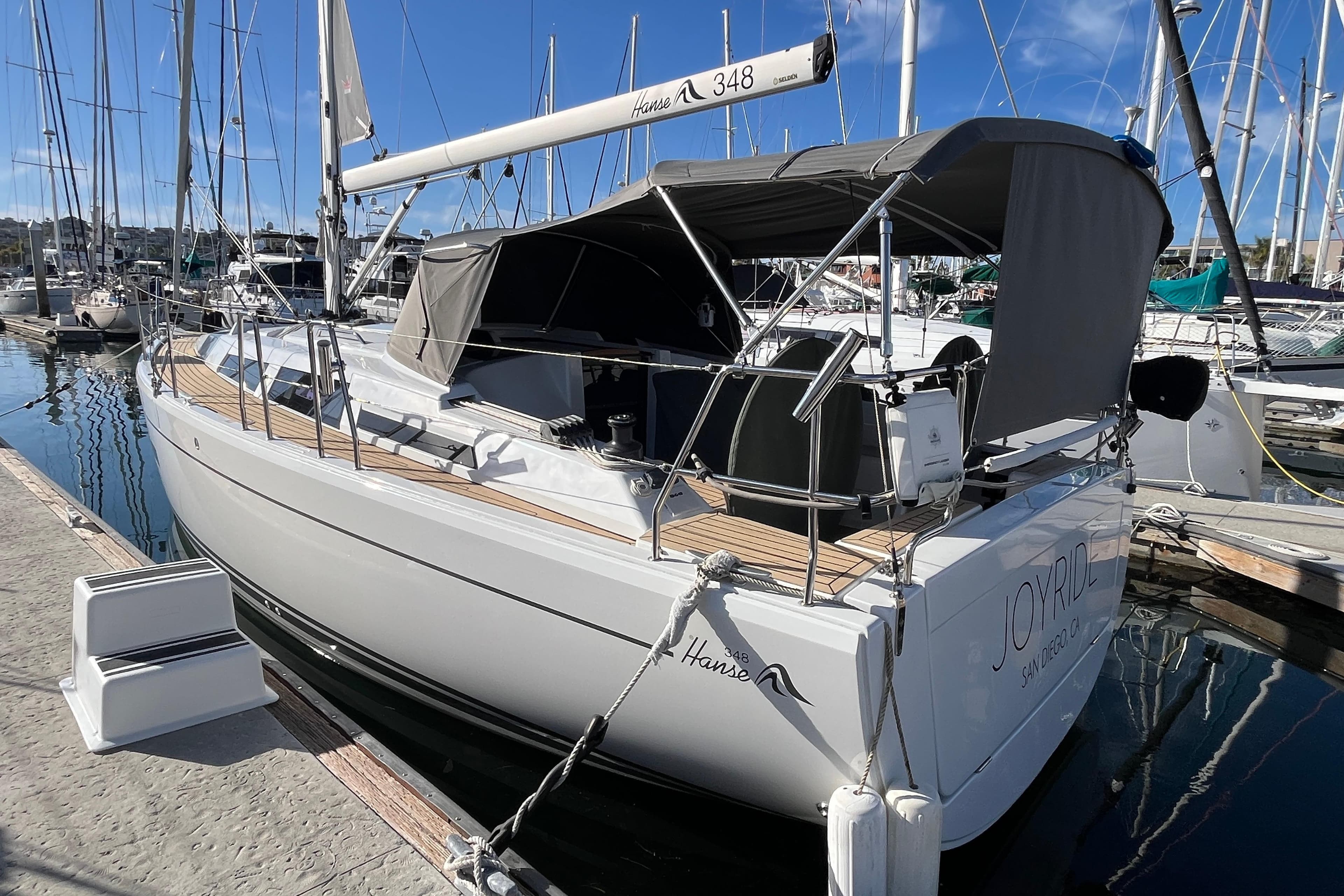 2021 Hanse 348 sailboat docked at marina, featuring sleek design and covered cockpit.