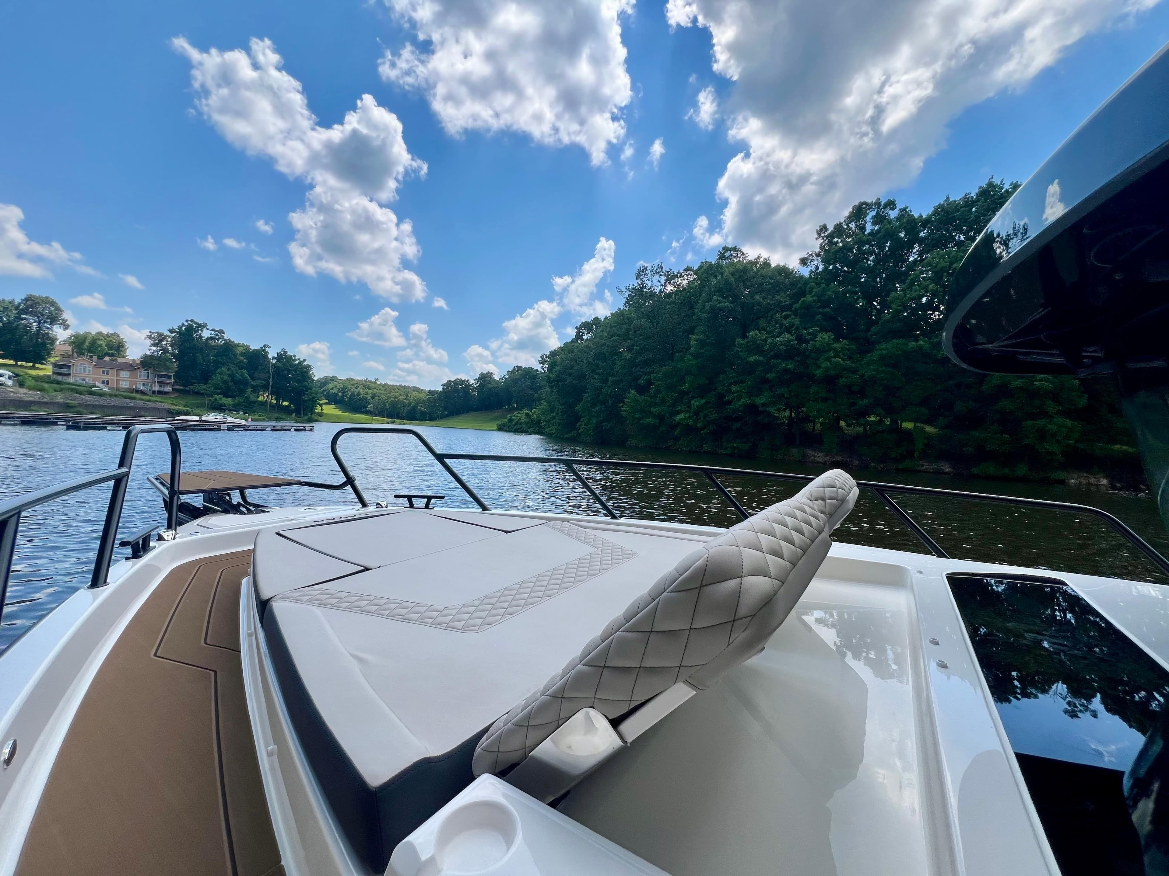 Luxurious Navan C30 boat on a serene lake under a clear blue sky.