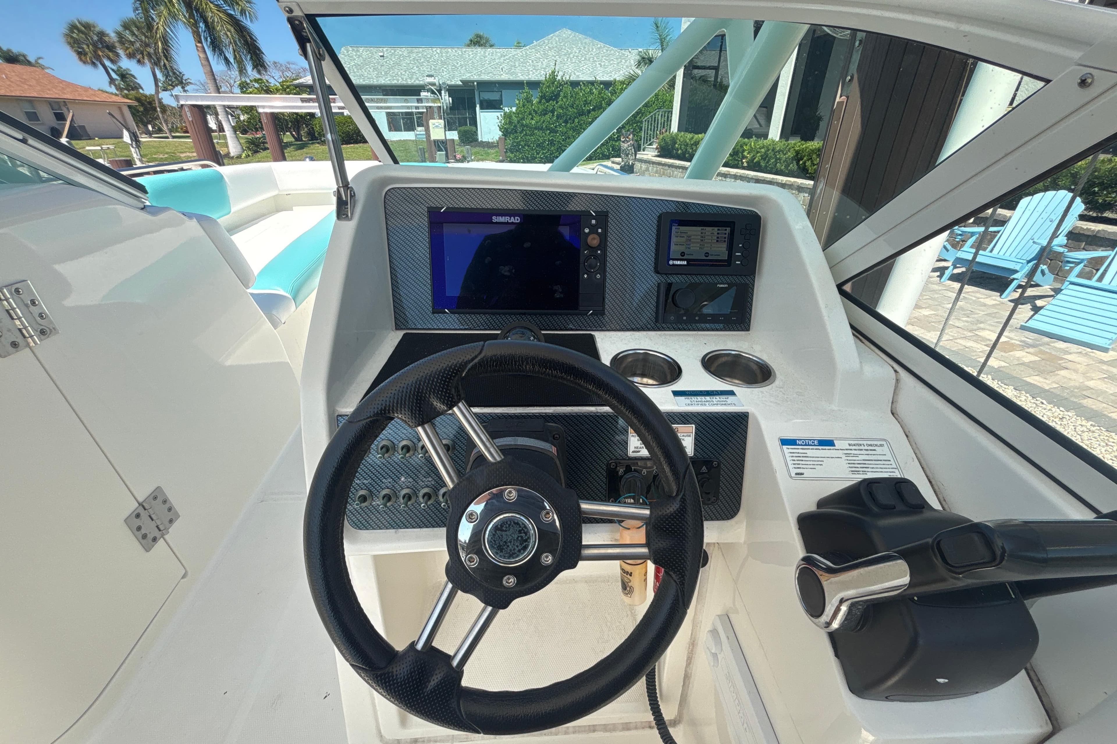 Cockpit of 2018 World Cat 230 SD boat with steering wheel and navigation system.