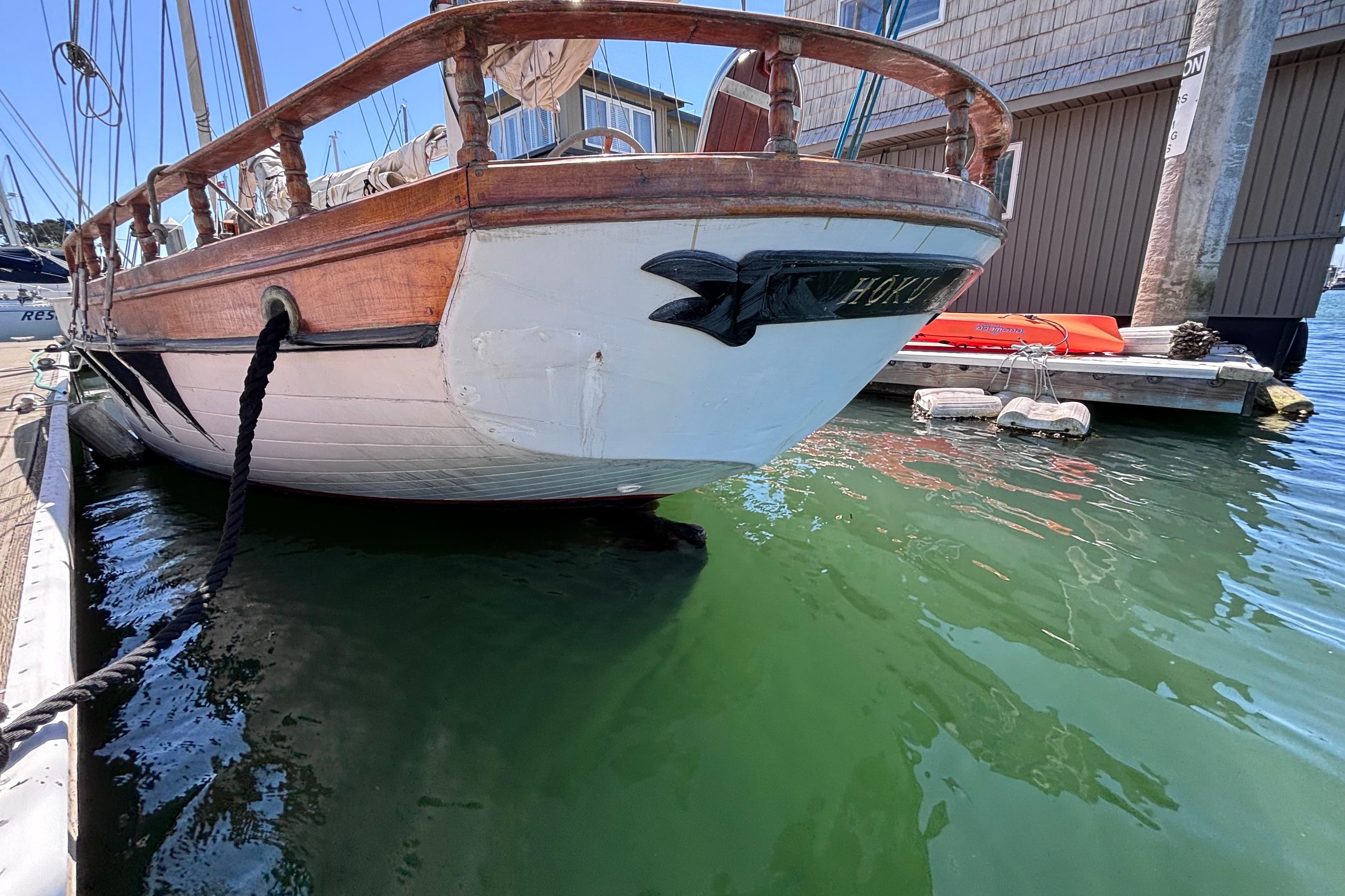 Vintage Chen sailboat from 1970 docked in a marina, featuring wooden railings.