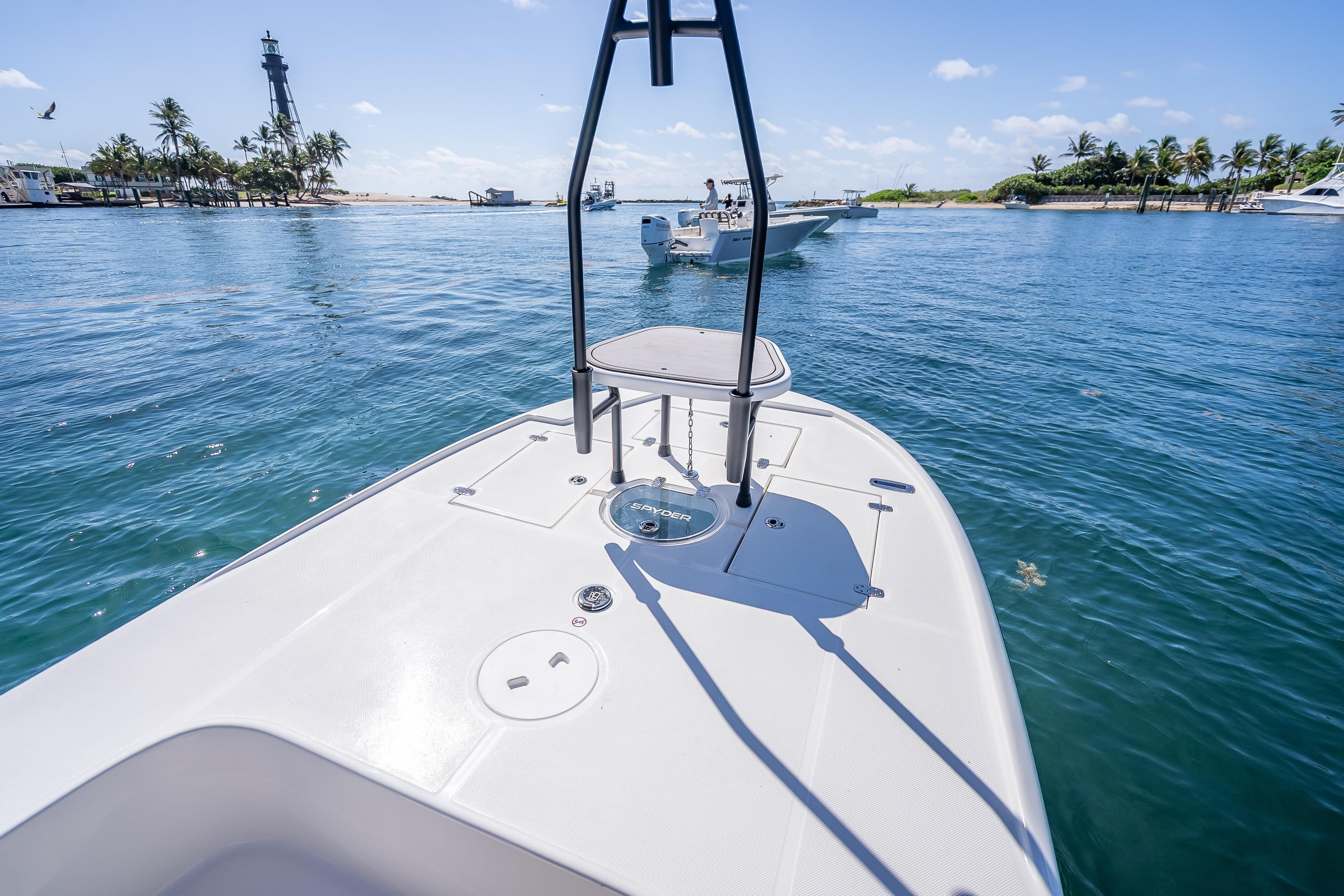 2026 Spyder FX19 Vapor boat on clear blue water near a lighthouse and palm trees.