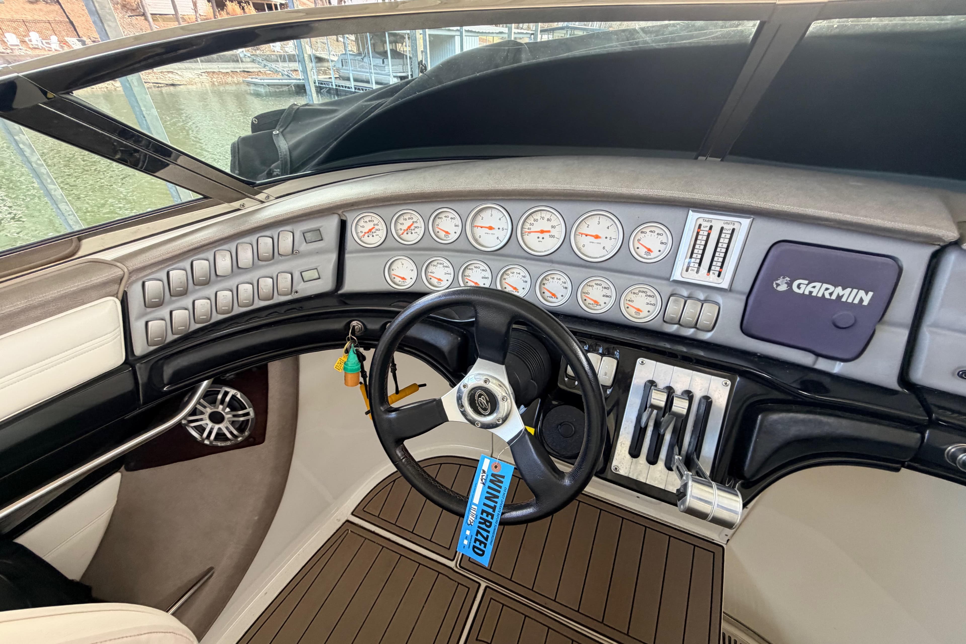 Dashboard of a 2004 Cobalt 343 boat with steering wheel and Garmin navigation system.