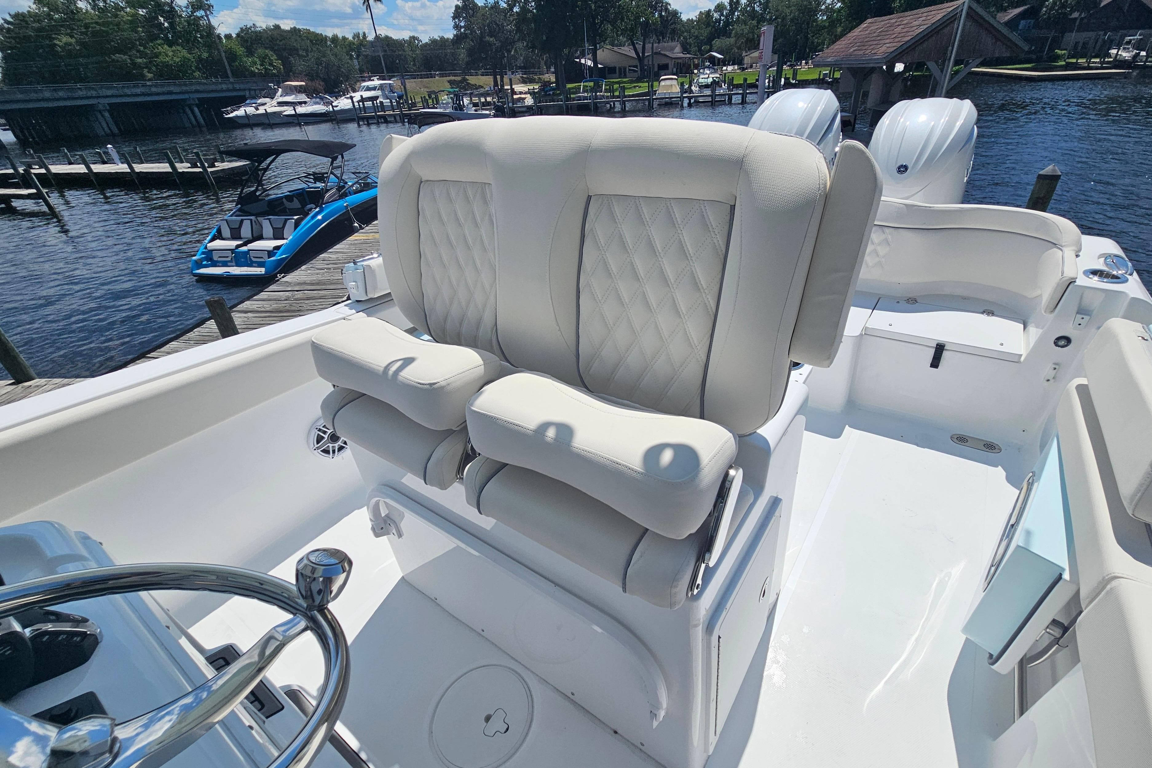 2026 Sea Hunt Ultra 265 SE boat with luxurious seating and dual engines at a marina.