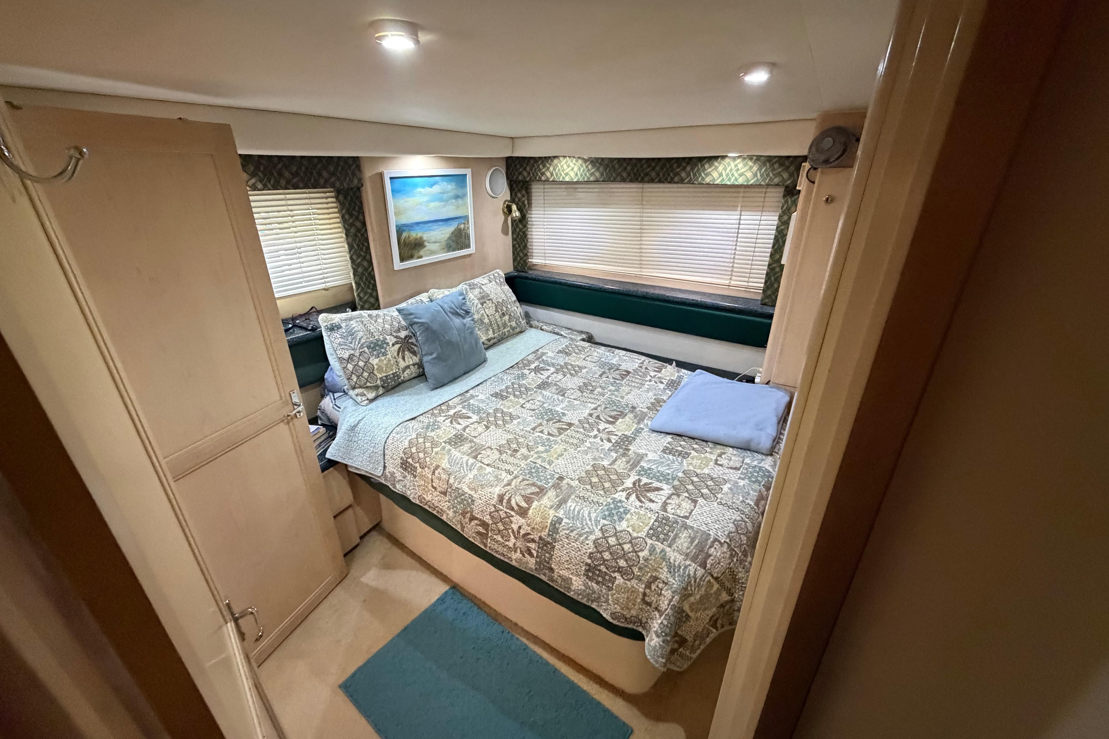Interior of 2000 Carver 356 Aft Cabin Motor Yacht bedroom with cozy decor.