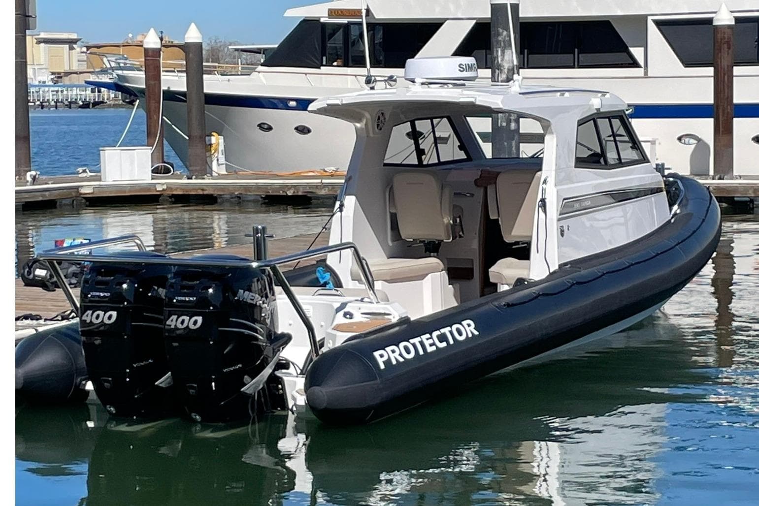 2024 Protector 330 Targa boat with twin 400 HP engines docked in marina.