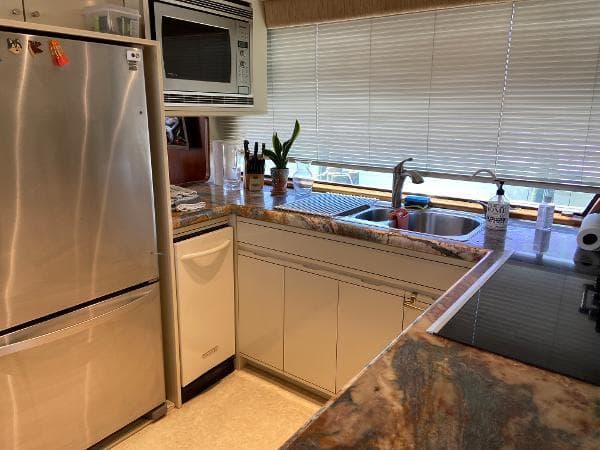 Kitchen interior of 1990 Viking Extended Aft Deck Motor Yacht with modern appliances and marble countertops.